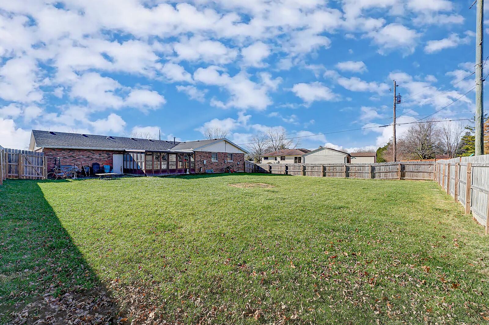 The rear of the home features a sunroom with built-in bar, concrete patio and a wood privacy fence. Contributed photo