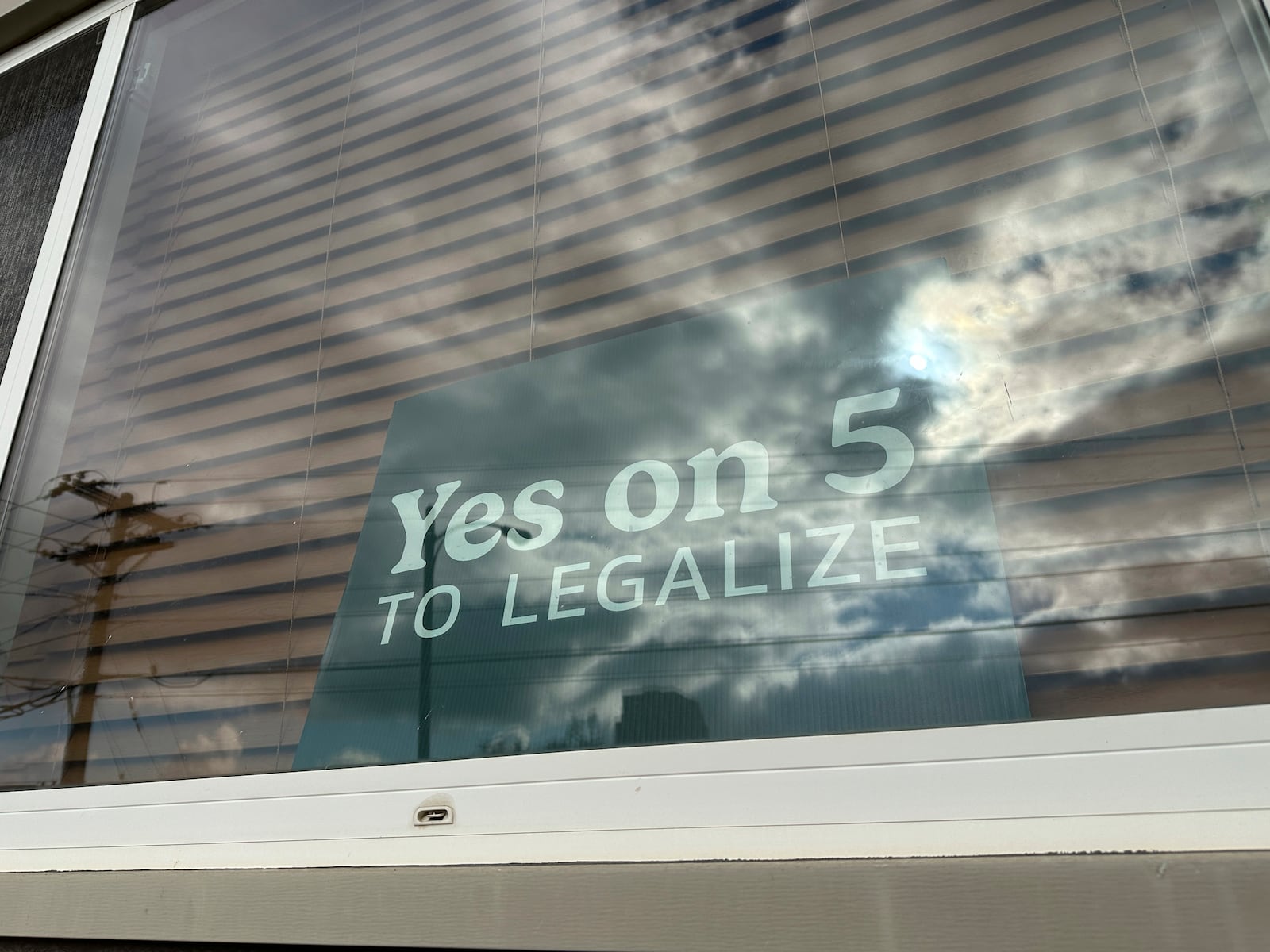 A sign in an apartment window in Bismarck, N.D., on Wednesday, Oct. 30, 2024, reads “Yes on 5 to legalize” in support of a ballot initiative that would legalize recreational marijuana in the state. (AP Photo/Jack Dura)