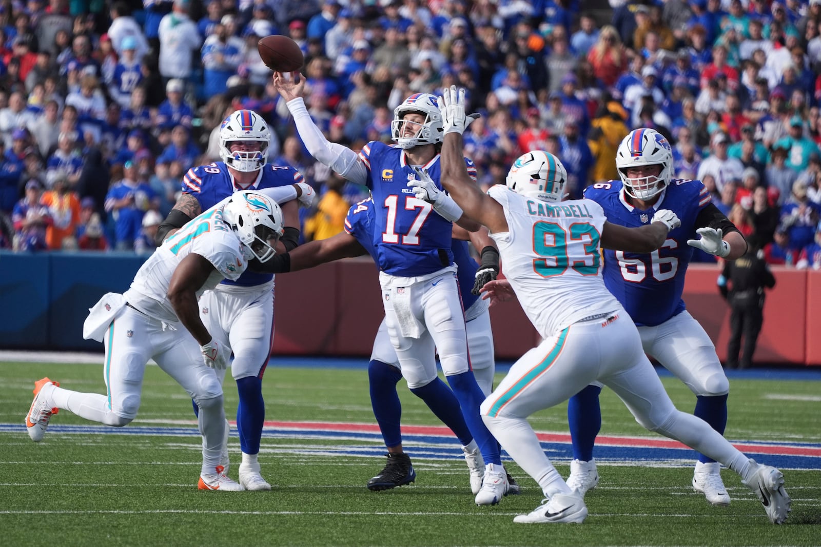 Buffalo Bills quarterback Josh Allen (17) is pressured by Miami Dolphins linebacker Tyus Bowser, left, and defensive tackle Calais Campbell (93) during the first half of an NFL football game Sunday, Nov. 3, 2024, in Orchard Park, N.Y. (AP Photo/Gene Puskar)