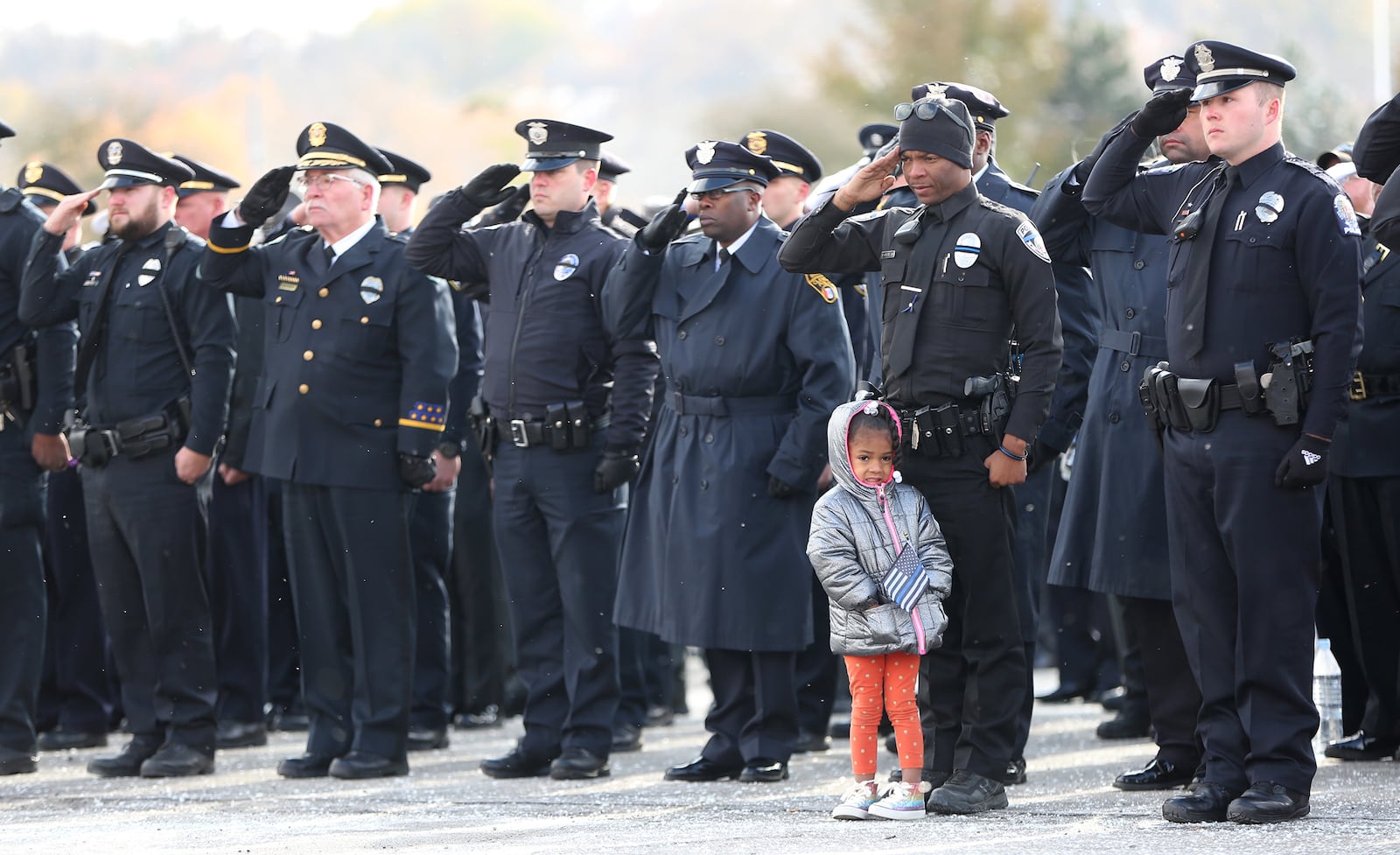 Union City Patrol Officer Darnell Pate brought his daughter, Bra'Lynn Pate to the funeral services for Dayton police Detective Jorge DelRio Nov. 12, 2019. LISA POWELL / STAFF