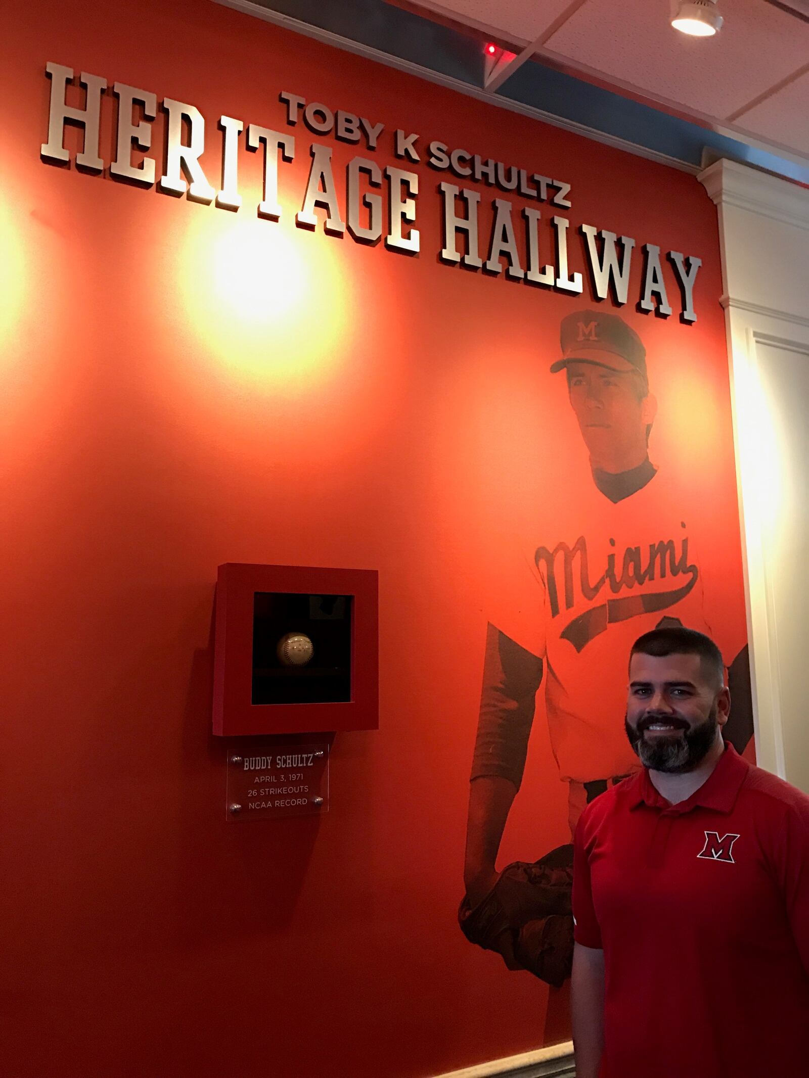 Miami baseball coach Danny Hayden alongside the baseball Buddy Schultz used to set an NCAA record 50 years ago. On April 3, 1971, the Miami left hander struck out 26 Wright State batters in the nine inning game. The record still stands today.  Behind Hayden is a photo of Schultz when he was an All Mid-American Conference pitcher for Miami.  He was drafted by the Chicago Cubs in 1972. Schultz was enshrined in the Miami Athletics Hall of Fame in 2010. He has been a tireless fundraiser (and a financial supporter himself) for the program.  Tom Archdeacon/STAFF