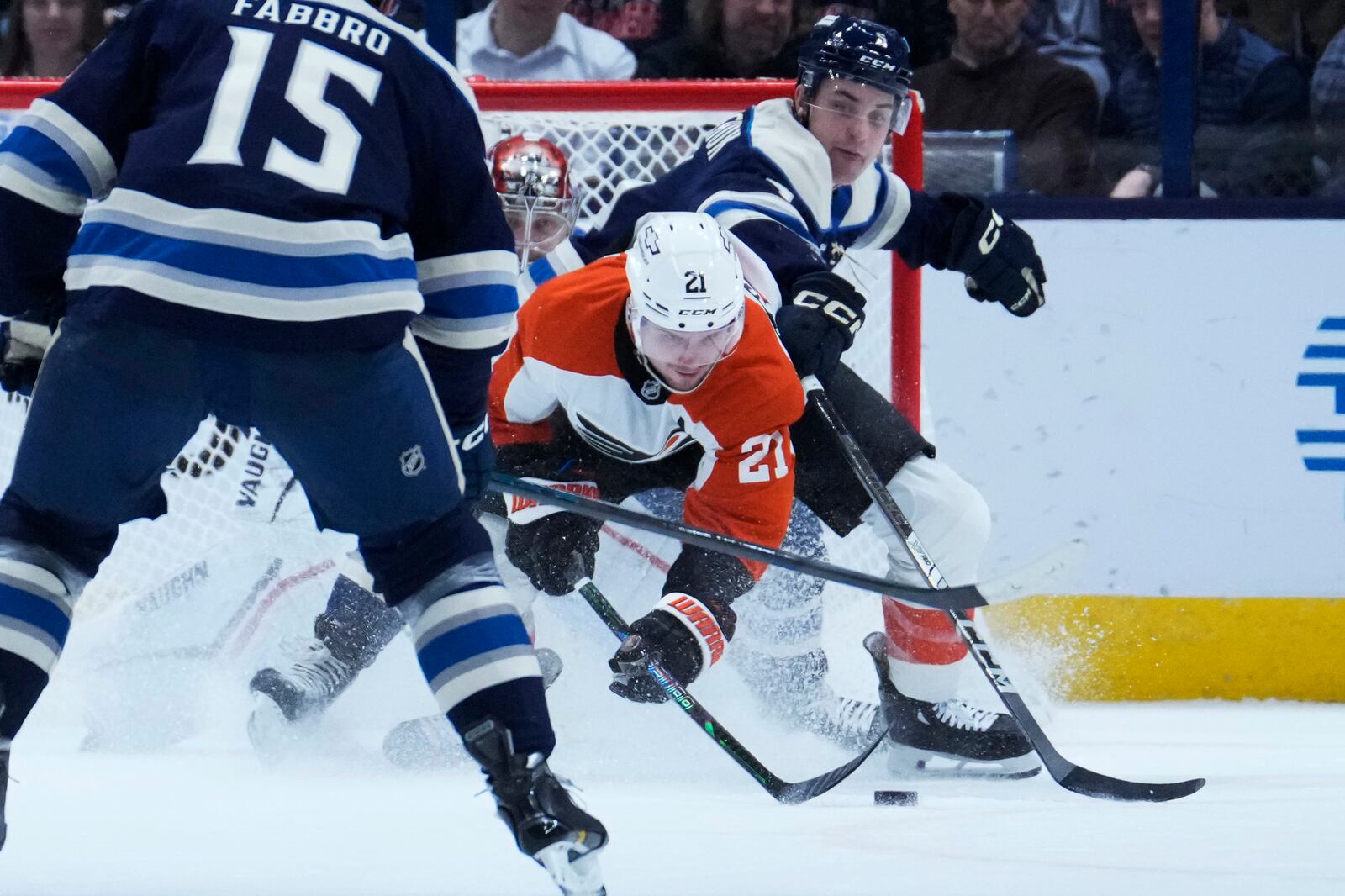 Philadelphia Flyers center Scott Laughton (21) reaches for the puck in front of Columbus Blue Jackets goaltender Daniil Tarasov, left, and defenseman Denton Mateychuk, right, in the second period of an NHL hockey game Tuesday, Jan. 14, 2025, in Columbus, Ohio. (AP Photo/Sue Ogrocki)