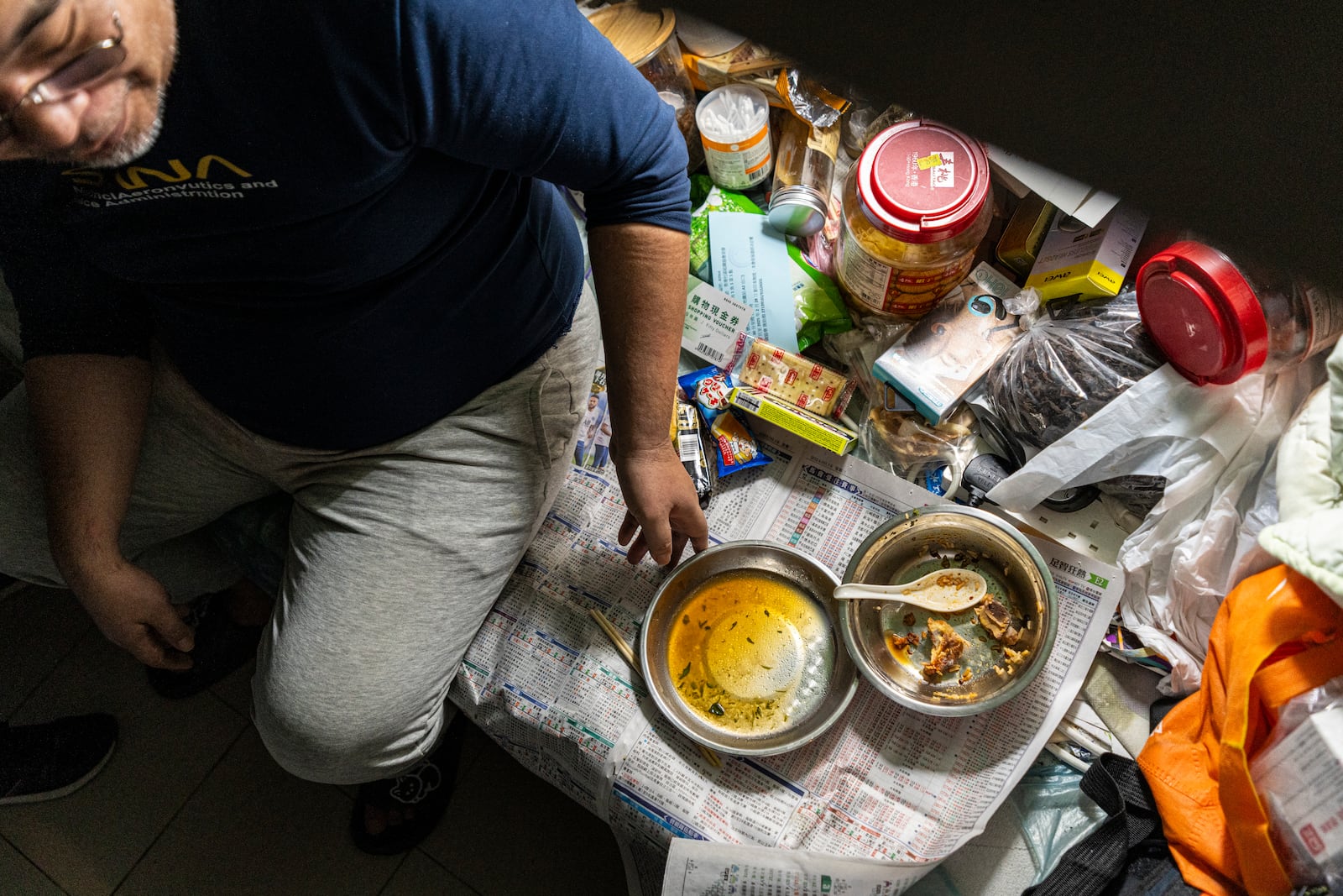 Resident Law Chung-yu has dinner in his bed space in Sham Shui Po district of Hong Kong, on Feb. 6, 2025. (AP Photo/Chan Long Hei)