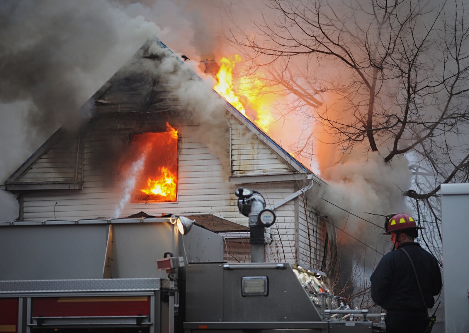 One person is custody in connection to a  house fire in the 2600 block of East Second Street of Dayton on Monday morning. Two people jumped out of the window of the burning home. Dayton Fire Department Chief Jeff Lykins said that the fire is believed to be arson. MARSHALL GORBY/STAFF