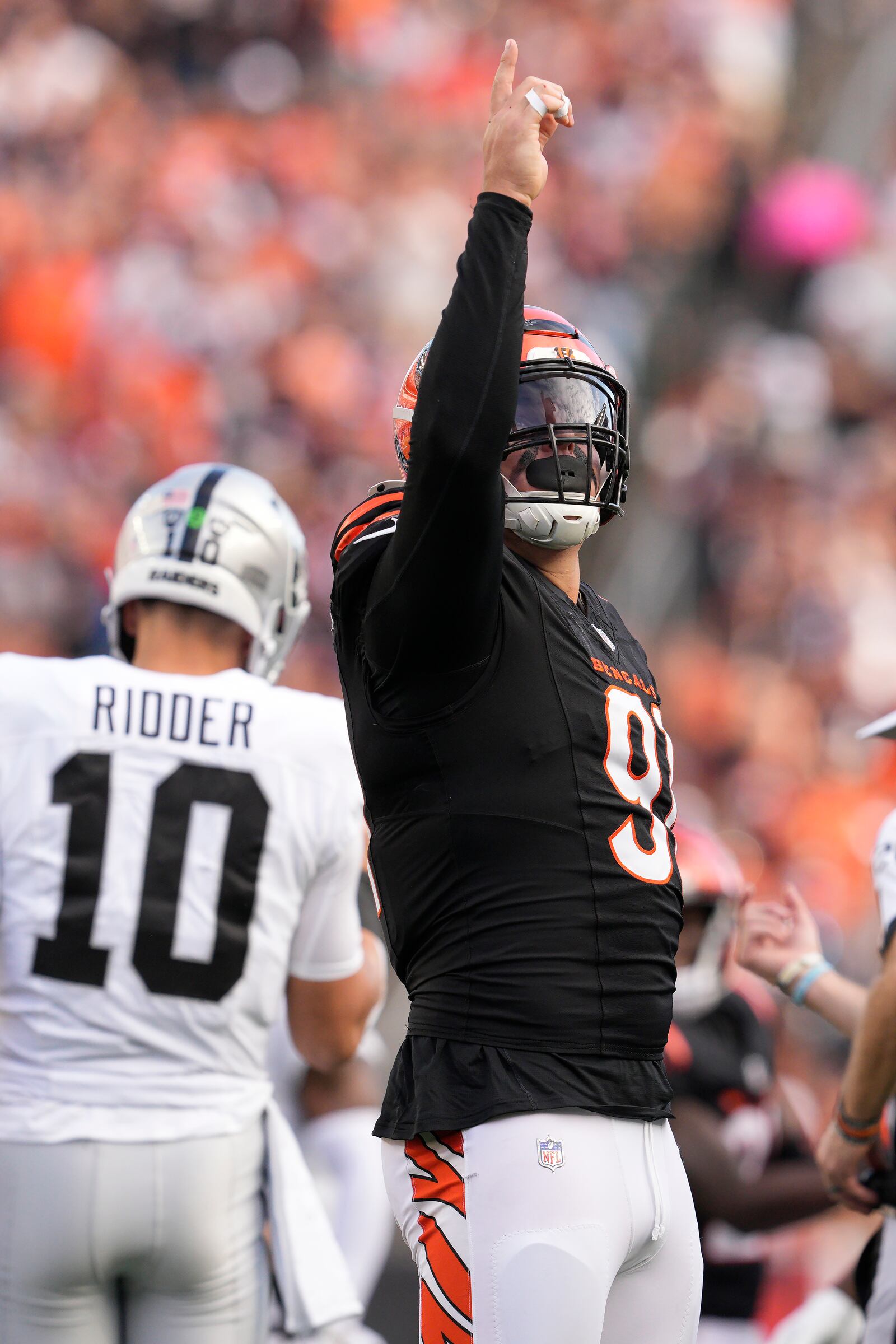 Cincinnati Bengals defensive end Trey Hendrickson, foreground, reacts after sacking Las Vegas Raiders quarterback Desmond Ridder (10) during the second half of an NFL football game in Cincinnati, Sunday, Nov. 3, 2024. (AP Photo/Jeff Dean)