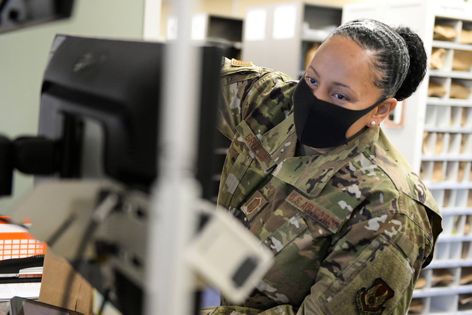 Chief Master Sgt. Theresa Grolla, Air Force Materiel Command financial management chief enlisted manager, reaches into a prescription bag to verify its contents while volunteering at the Kittyhawk Pharmacy Aug. 7. (U.S. Air Force photo/Wesley Farnsworth)