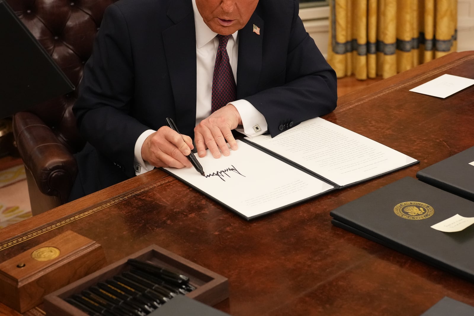 President Donald Trump signs executive orders in the Oval Office of the White House in Washington on Monday, Jan. 20, 2025. (Doug Mills/The New York Times)
                      