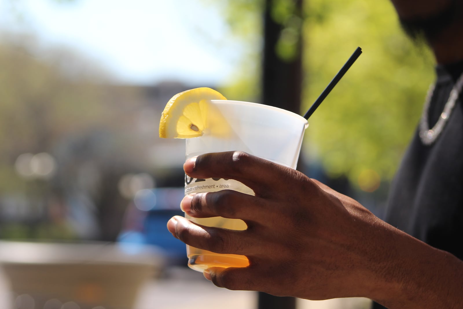 A visitor to the Oregon District on Thursday holds a mixed alcoholic drink while hanging out on Fifth Street. Visitors can drink alcohol on the street that come in special cups as part of the Designated Outdoor Refreshment Area (DORA). CORNELIUS FROLIK / STAFF