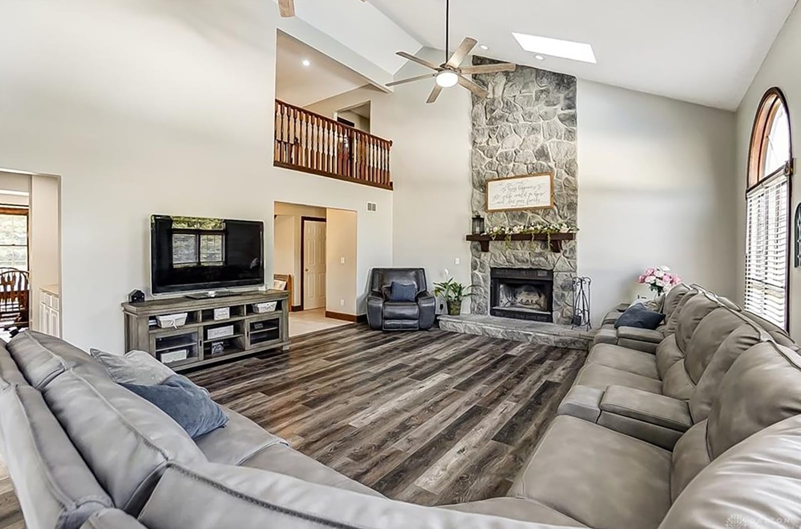 The great room has newer luxury vinyl tile flooring, a vaulted ceiling with skylights and palladium windows overlooking the rear deck.