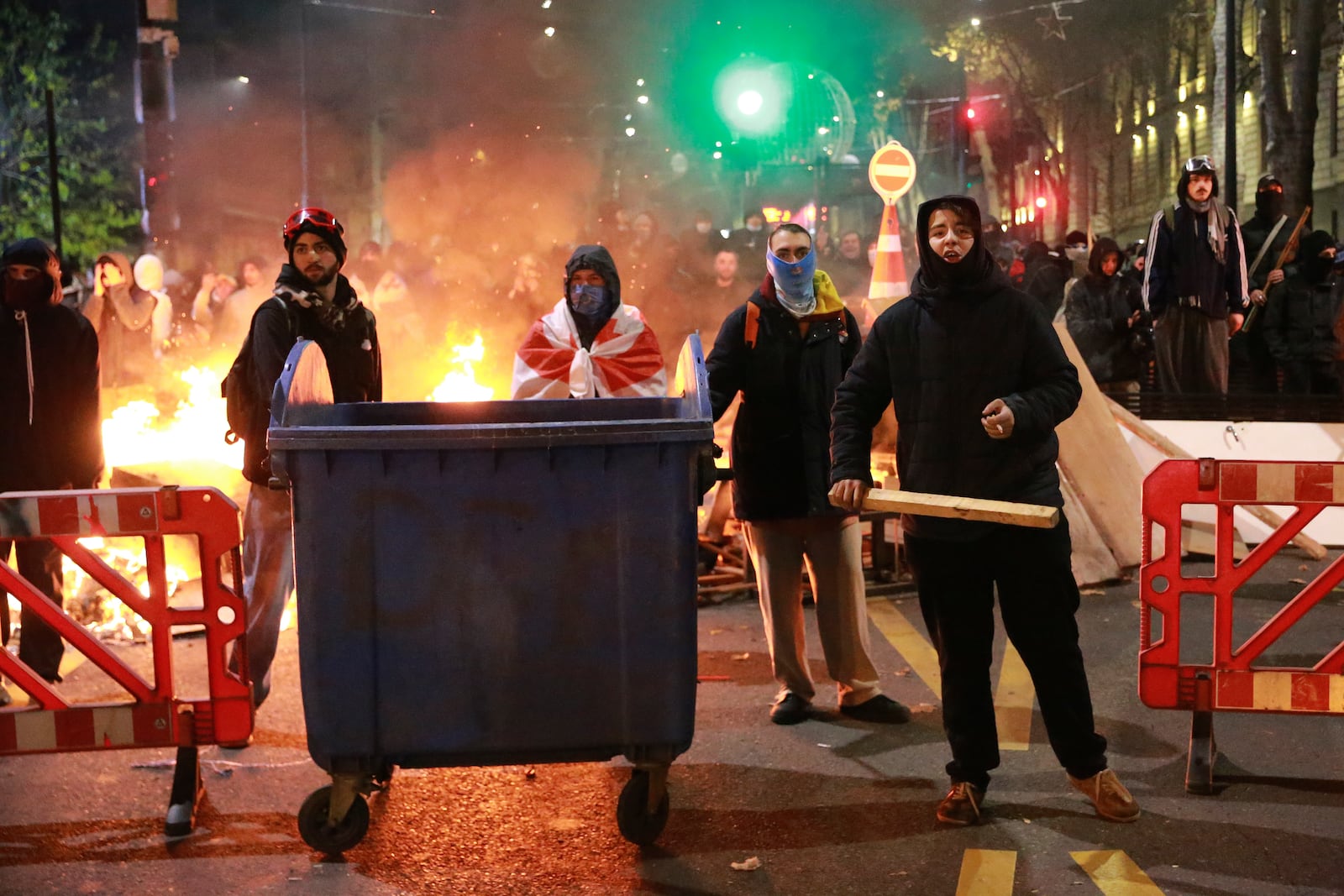 Demonstrators stand at a barricade during protests against the government's decision to suspend negotiations on joining the European Union in Tbilisi, Georgia, early Tuesday, Dec. 3, 2024. (AP Photo/Zurab Tsertsvadze)