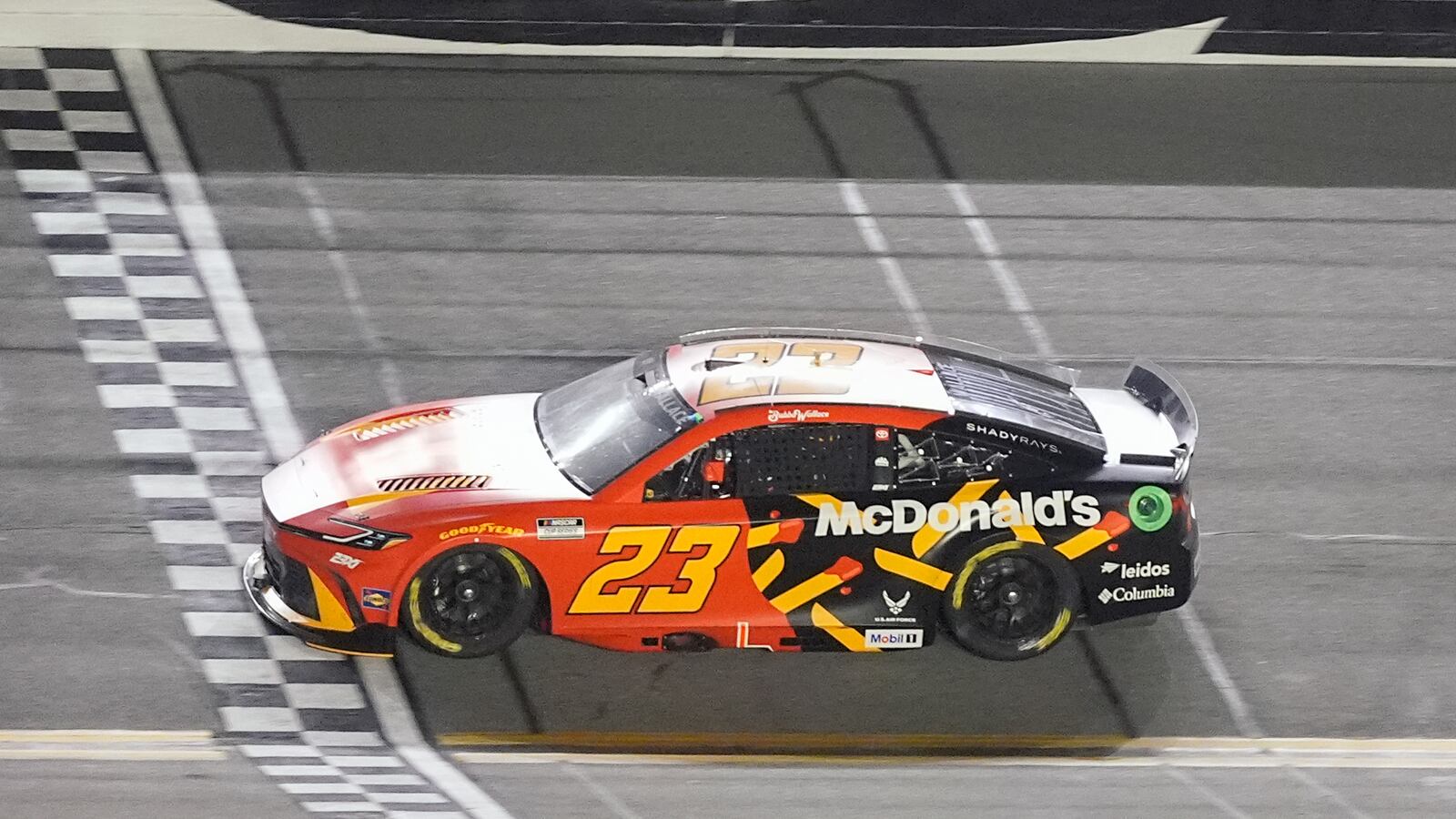 Bubba Wallace (23) crosses the finish line to win the first of two NASCAR Daytona 500 qualifying auto races at Daytona International Speedway, Thursday, Feb. 13, 2025, in Daytona Beach, Fla. (AP Photo/John Raoux)