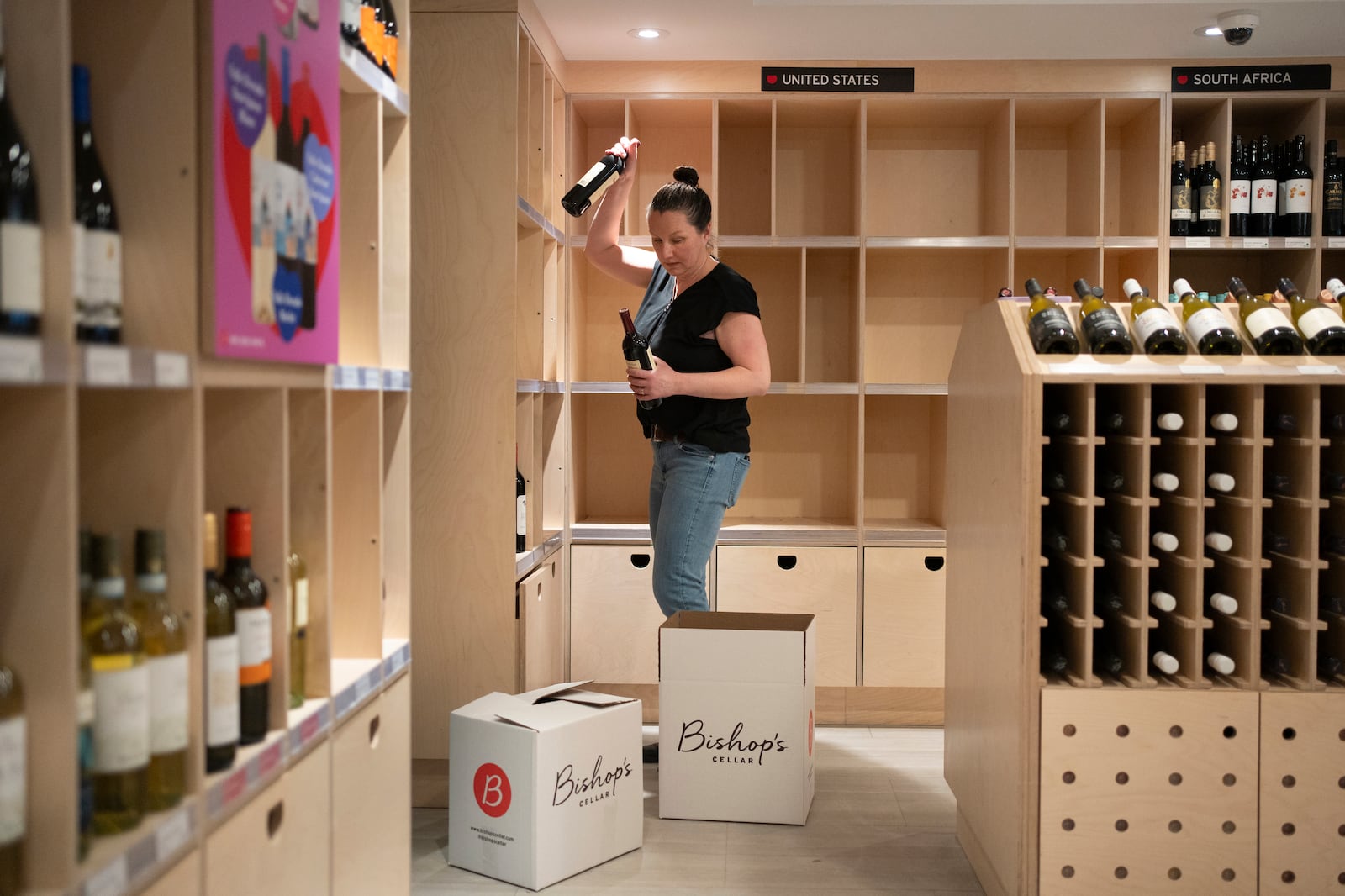 An employee removes American-made wine from their shelves at Bishop's Cellar in Halifax on Wednesday, March 5, 2025. (Darren Calabrese /The Canadian Press via AP)