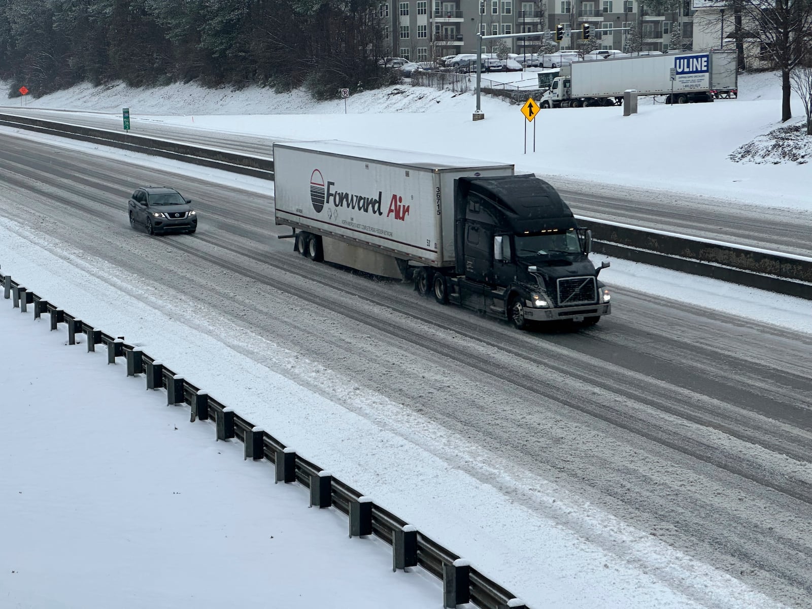 /// A truck picks its way along a slushy Interstate 285 northeast of downtown in Atlanta on Friday, Jan. 10, 2025. (AP Photo/Jeff Amy)