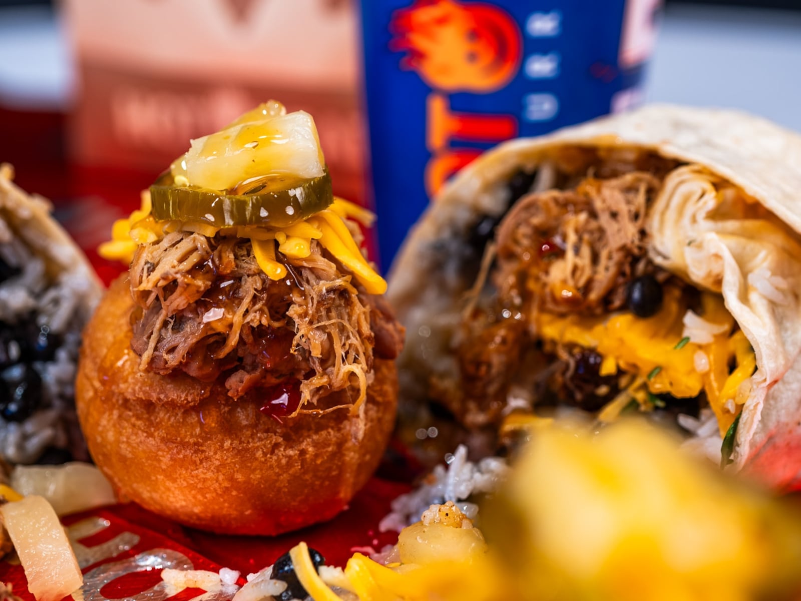 Death Grip Donuts and Hot Head Burritos are teaming up for two special pop-up events at The Mall at Fairfield Commons in Beavercreek. Pictured is The Hawaiian, a donut filled with refried beans, pork and sweet habanero sauce that’s topped with shredded cheddar cheese, pineapple and jalapeño (CONTRIBUTED PHOTO).