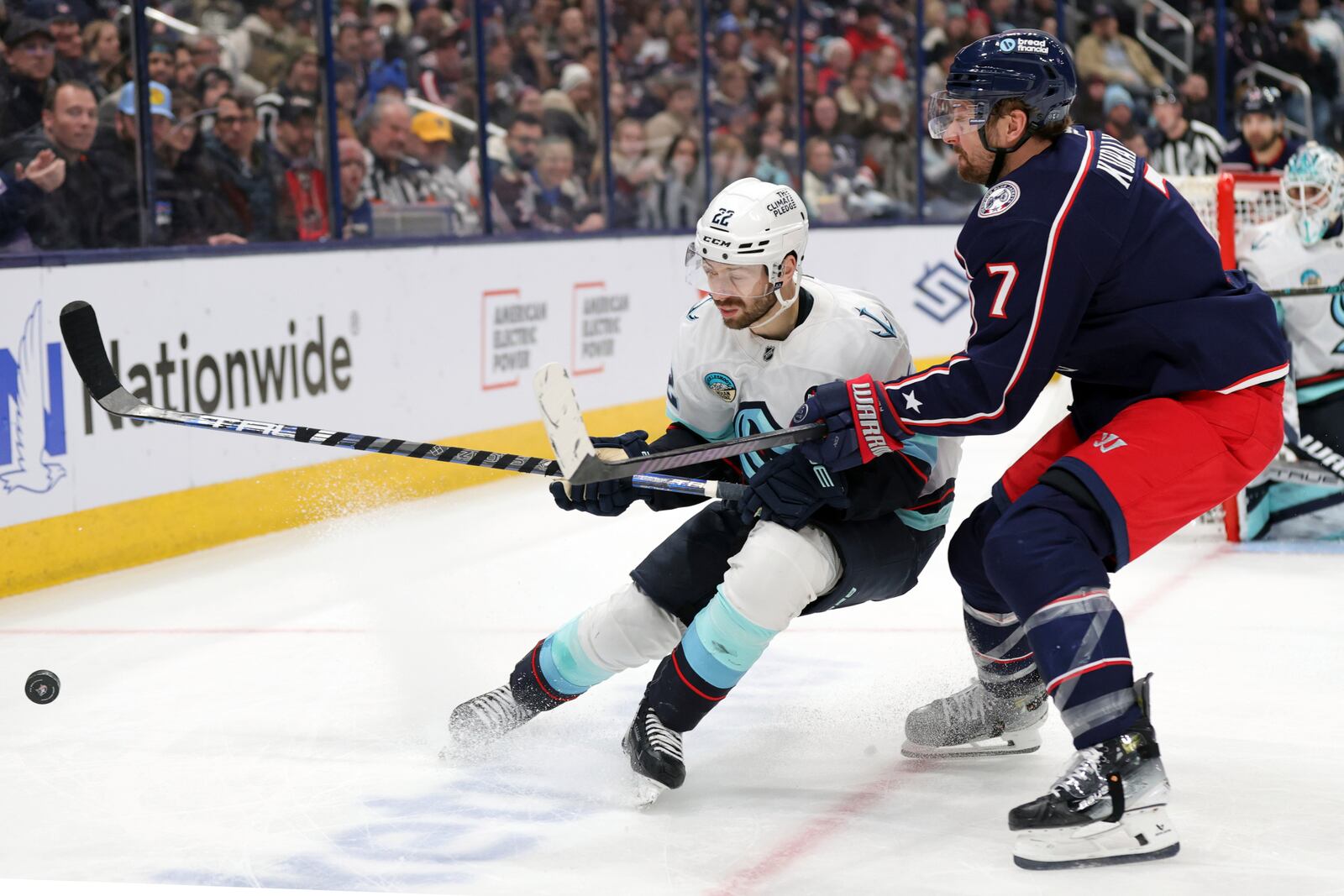 Seattle Kraken forward Oliver Bjorkstrand, left, and Columbus Blue Jackets forward Sean Kuraly, rght, chase the puck during the second period of an NHL hockey game in Columbus, Ohio, Thursday, Jan. 9, 2025. (AP Photo/Paul Vernon)