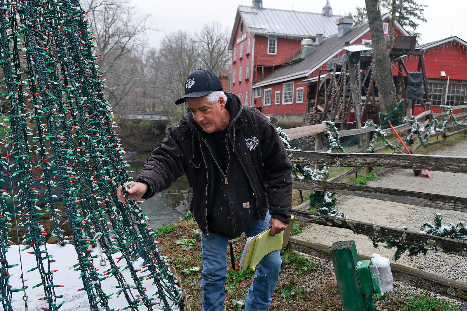 Anthony Satariano, who owns the Historic Clifton Mill with his mom, Pat, checks some of the nearly five million holiday lights before opening night. BILL LACKEY/STAFF