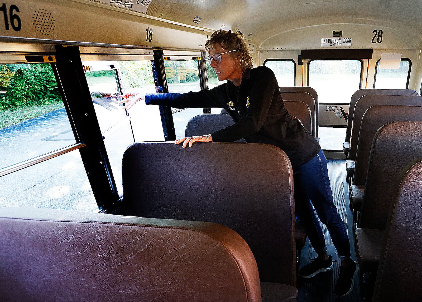 Centerville bus driver Denise Haws checks the emergency exits and goes through her safety checks Tuesday, Aug. 20, 2024 on her bus before picking students. These checks are done every day. MARSHALL GORBY\STAFF