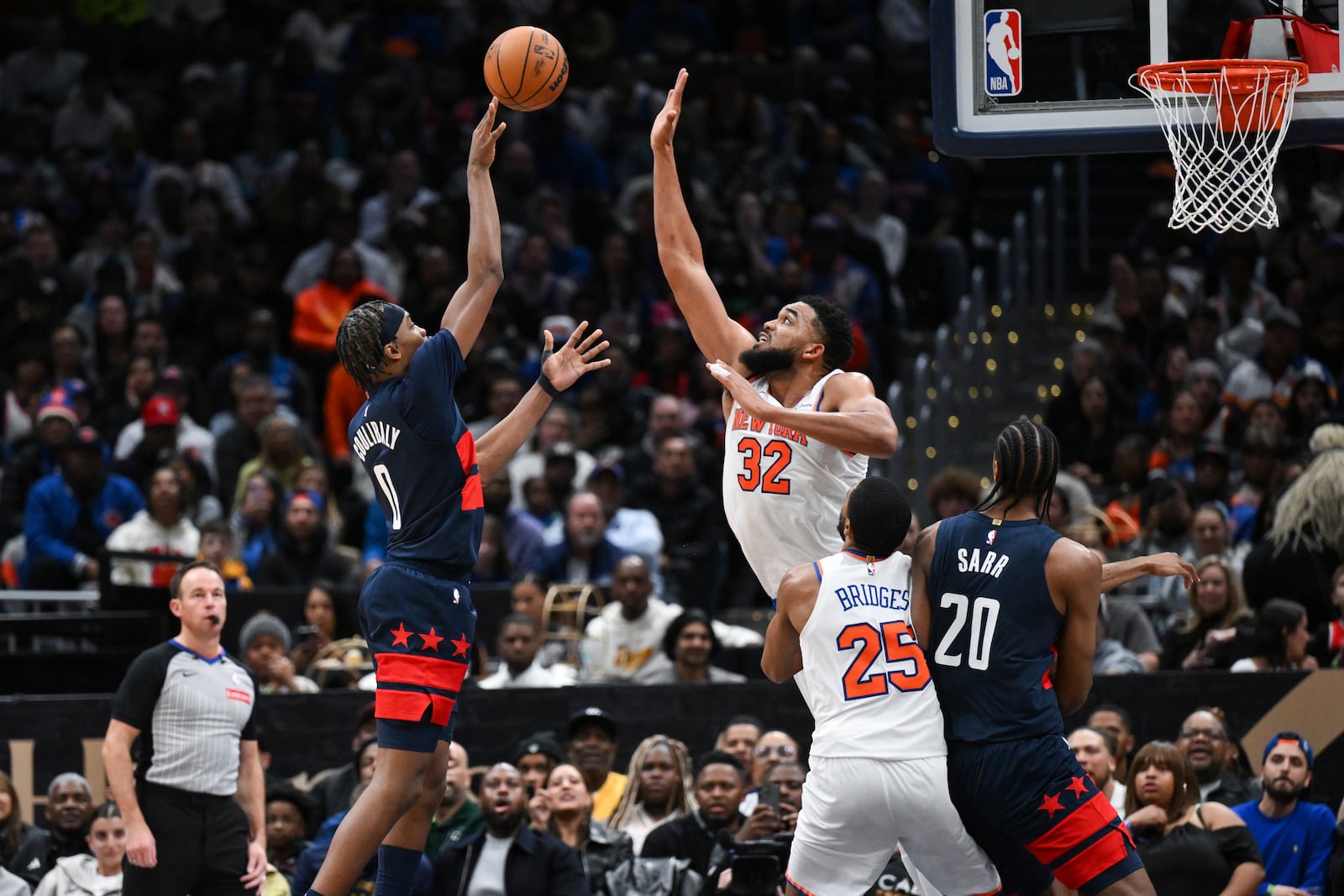 Washington Wizards guard Bilal Coulibaly (0) shoots the ball over New York Knicks center Karl-Anthony Towns (32) during the second half of an NBA basketball game, Saturday, Dec. 28, 2024, in Washington. (AP Photo/Terrance Williams)