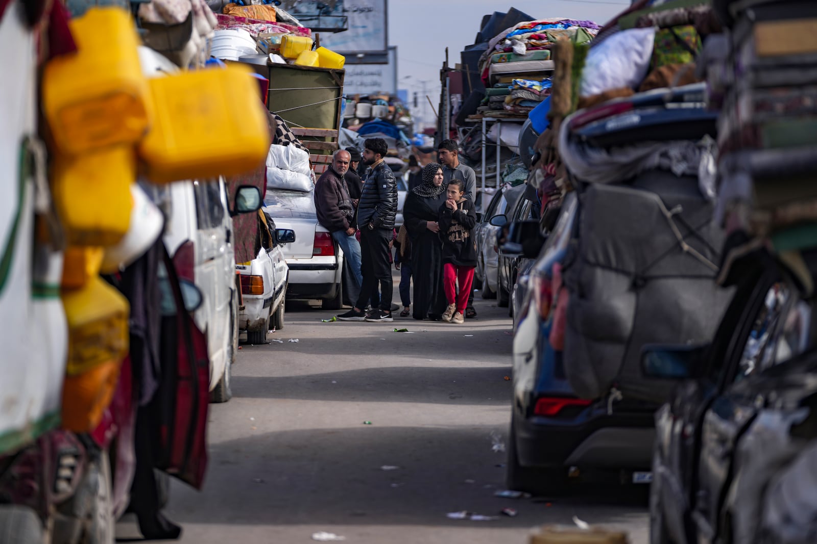 Displaced Palestinians with their belongings gather near a roadblock on Salah al-Din Street, as they wait to return to their homes in the northern part of the Gaza Strip, Sunday, Jan. 26, 2025, days after the ceasefire deal between Israel and Hamas came into effect. (AP Photo/Abdel Kareem Hana)