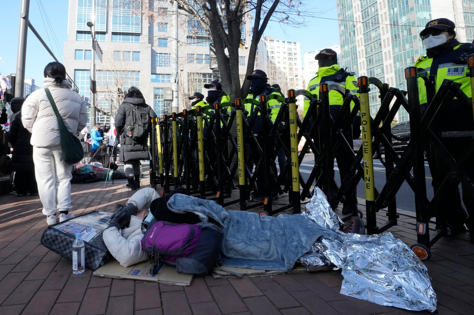 A supporter of impeached South Korean President Yoon Suk Yeol lies down on the ground during a rally to oppose his impeachment outside the Seoul Western District Court in Seoul, South Korea, Saturday, Jan. 18, 2025. (AP Photo/Ahn Young-joon)