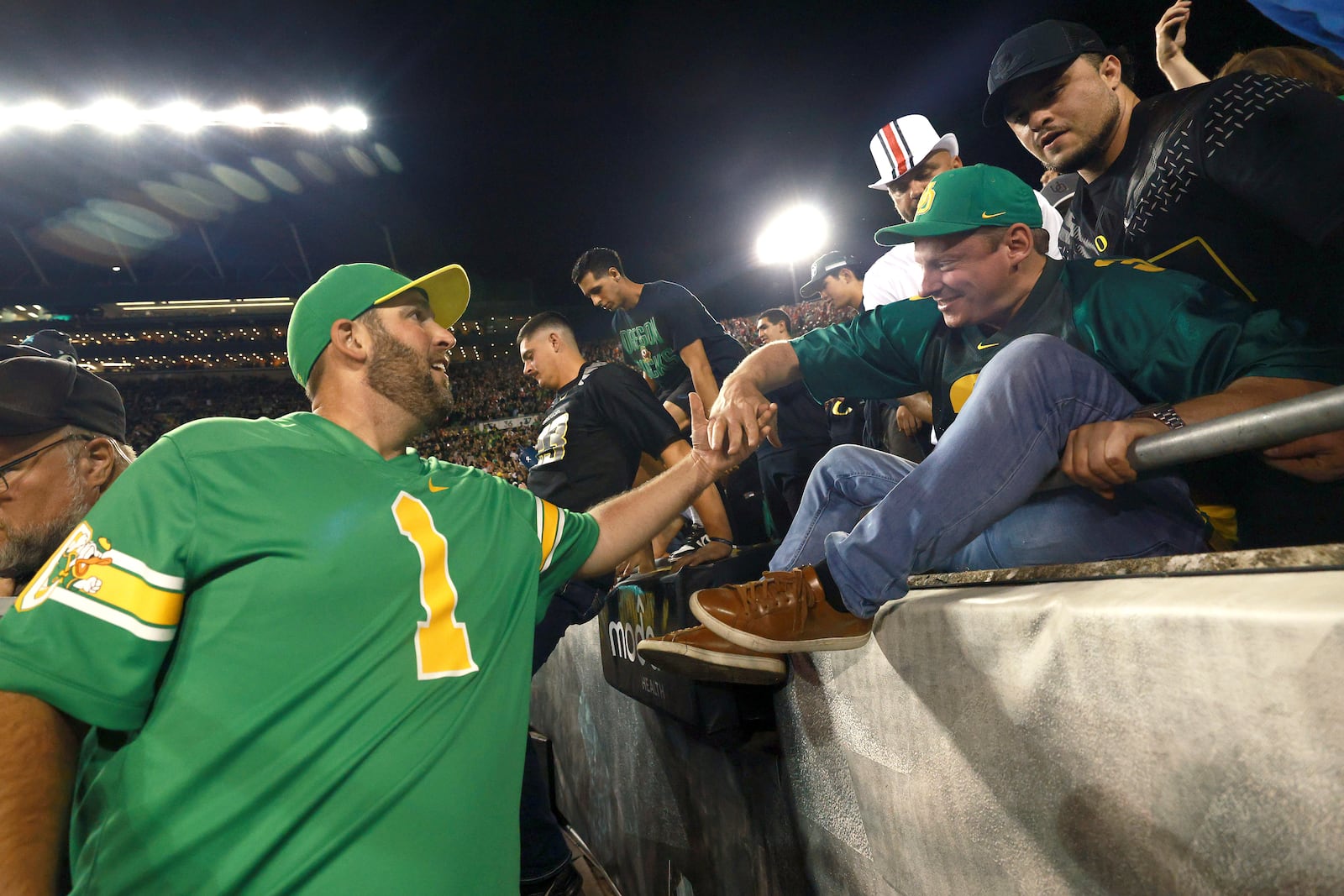 Oregon fans storm the field after Oregon's win over Ohio State in an NCAA college football game, Saturday, Oct. 12, 2024, in Eugene, Ore. (AP Photo/Lydia Ely)