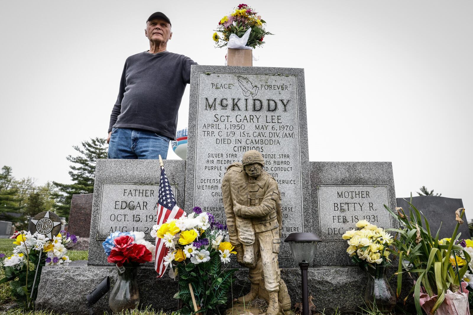 Jim Skaggs stands near the grave of Sgt. Gary McKiddy at Highland Memorial Cemetery in Miamisburg. Both men served together in Vietnam. McKiddy rescued Skaggs from a burning helicopter and died when the helicopter exploded.  JIM NOELKER/STAFF