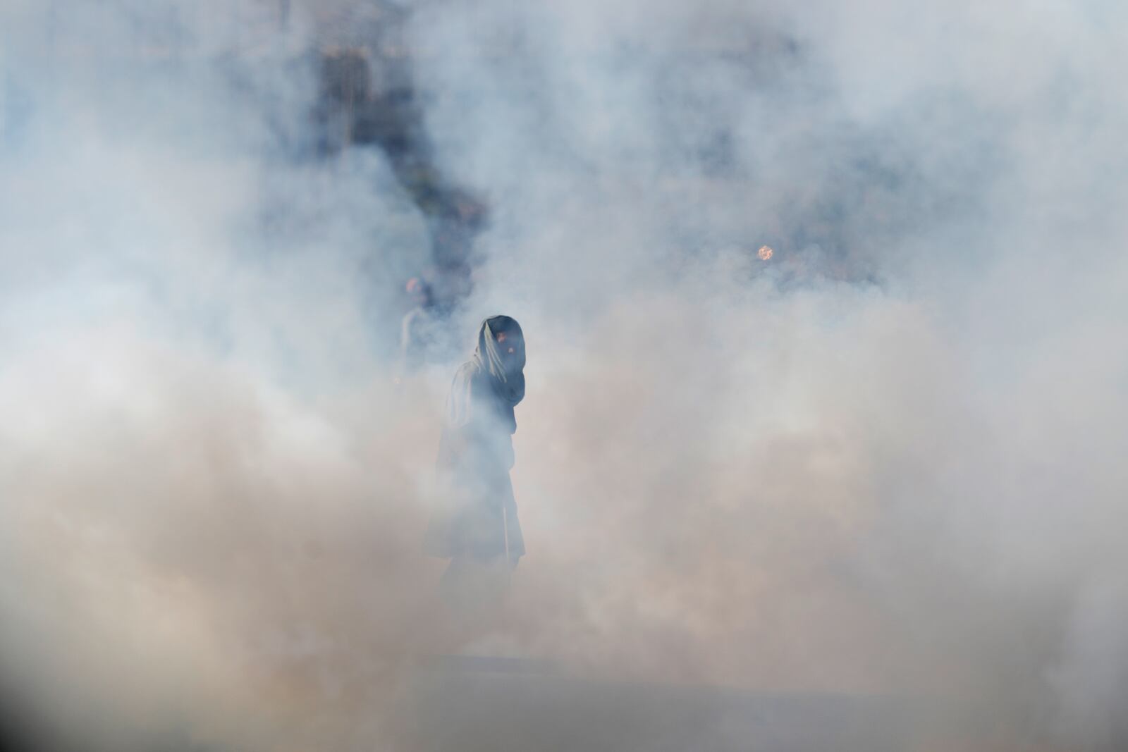 A supporter of imprisoned former premier Imran Khan's Pakistan Tehreek-e-Insaf party, runs for cover after police fire tear gas shell to disperse them during clashes, in Islamabad, Pakistan, Tuesday, Nov. 26, 2024. (AP Photo/Anjum Naveed)