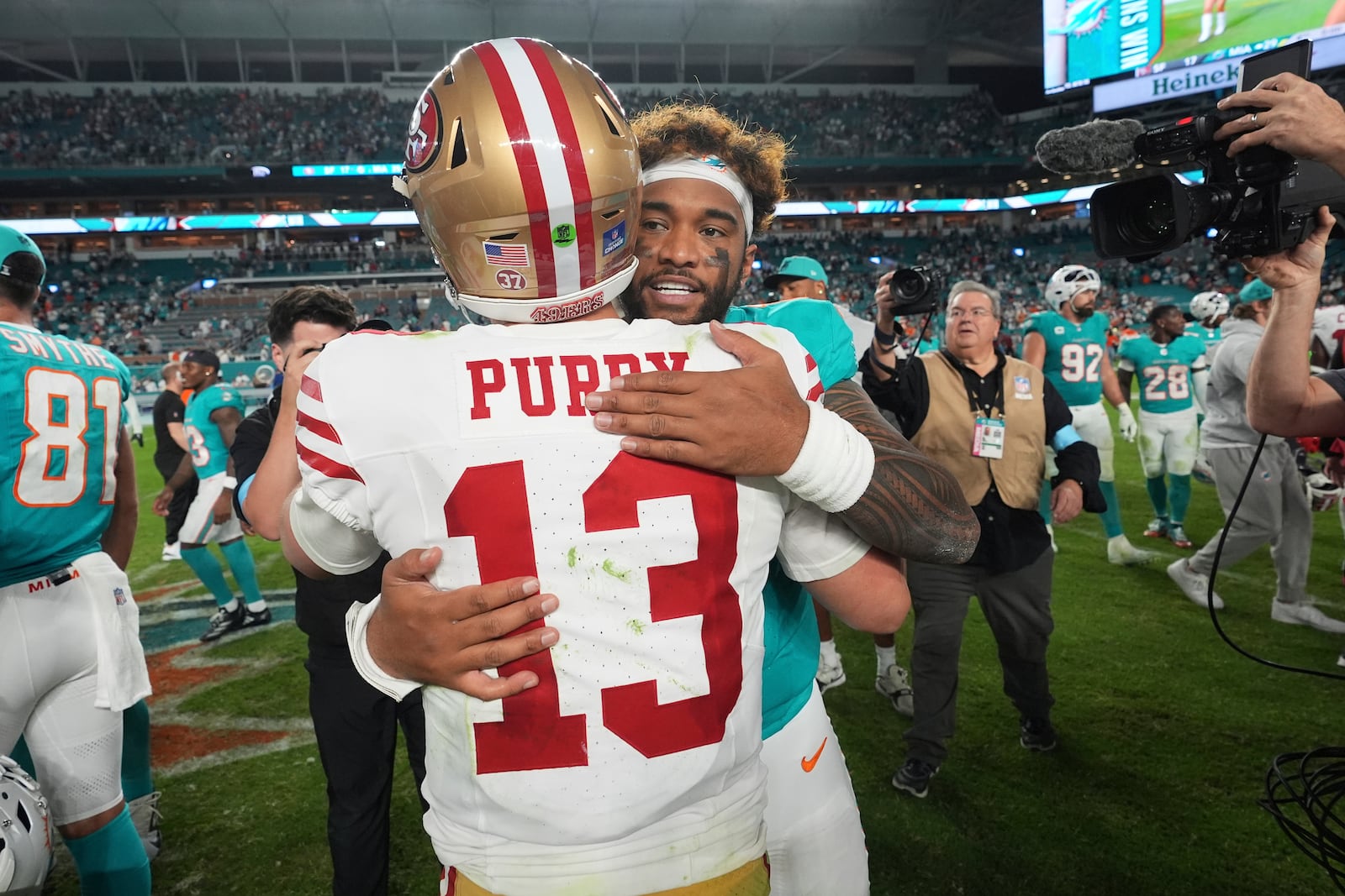 Miami Dolphins quarterback Tua Tagovailoa and San Francisco 49ers quarterback Brock Purdy (13) embrace at the end of an NFL football game, Sunday, Dec. 22, 2024, in Miami Gardens, Fla. (AP Photo/Rebecca Blackwell)