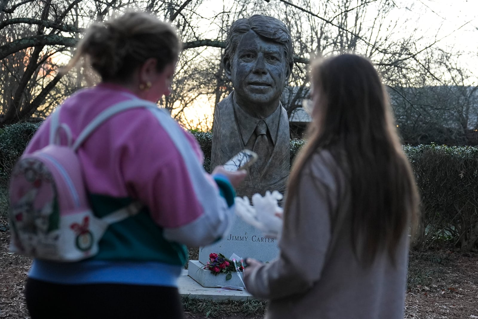 People visit a bust of former President Jimmy Carter at the Jimmy Carter Presidential Library and Museum on Sunday, Dec. 29, 2024, in Atlanta. (AP Photo/Brynn Anderson)