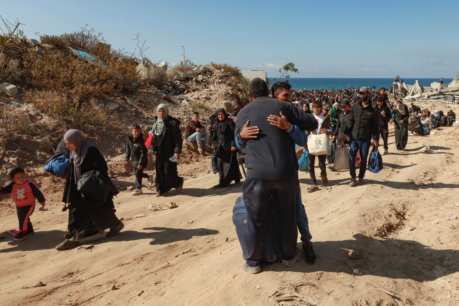 Relatives hug each other, as displaced Palestinians arrive in the northern Gaza Strip, following Israel's decision to allow thousands of them to go back for the first time since the early weeks of the 15-month war with Hamas, Monday, Jan. 27, 2025. (AP Photo/Abed Hajjar)