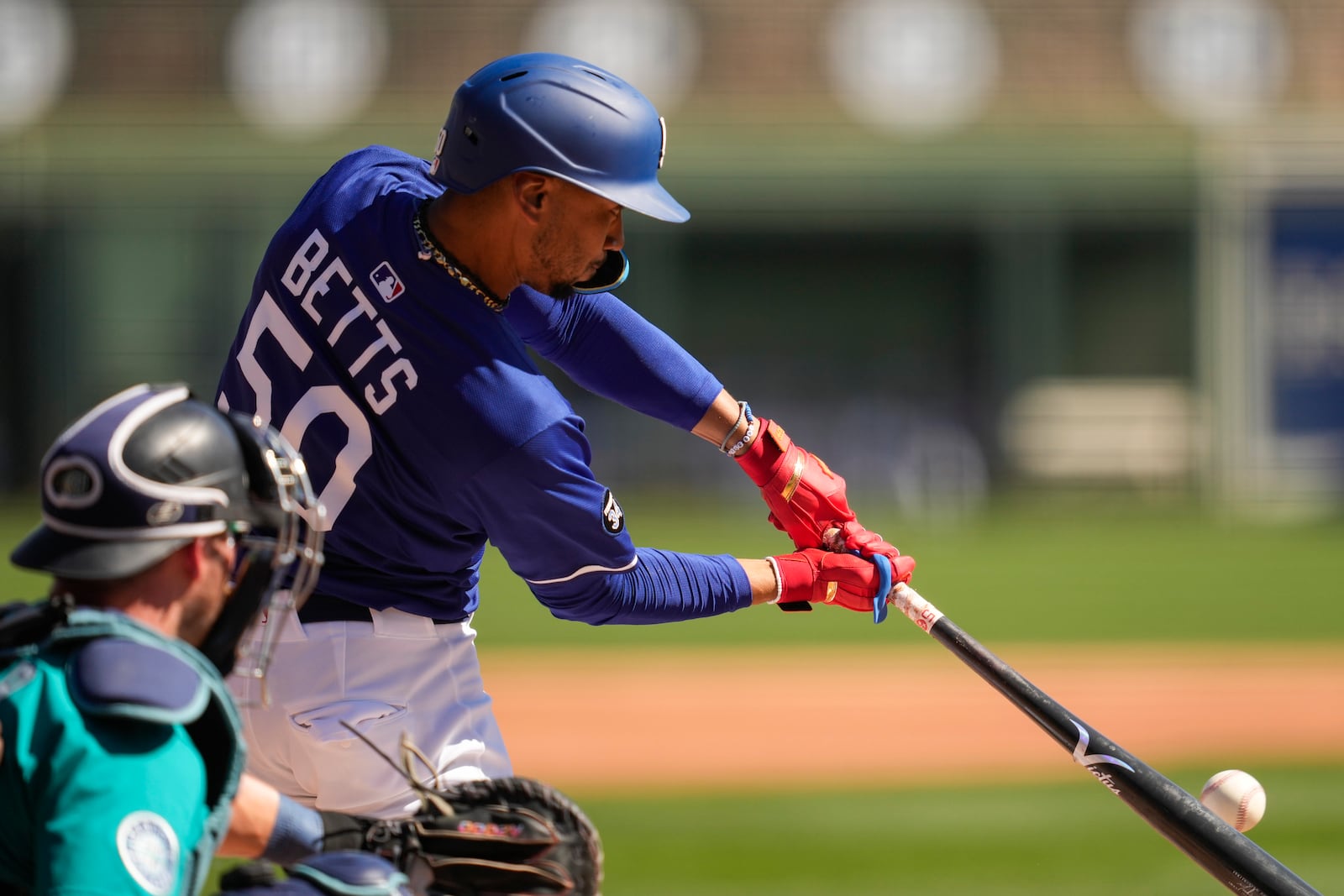 Los Angeles Dodgers' Mookie Betts singles during the first inning during a spring training baseball game against the Seattle Mariners, Tuesday, Feb. 25, 2025, in Phoenix. (AP Photo/Ashley Landis)