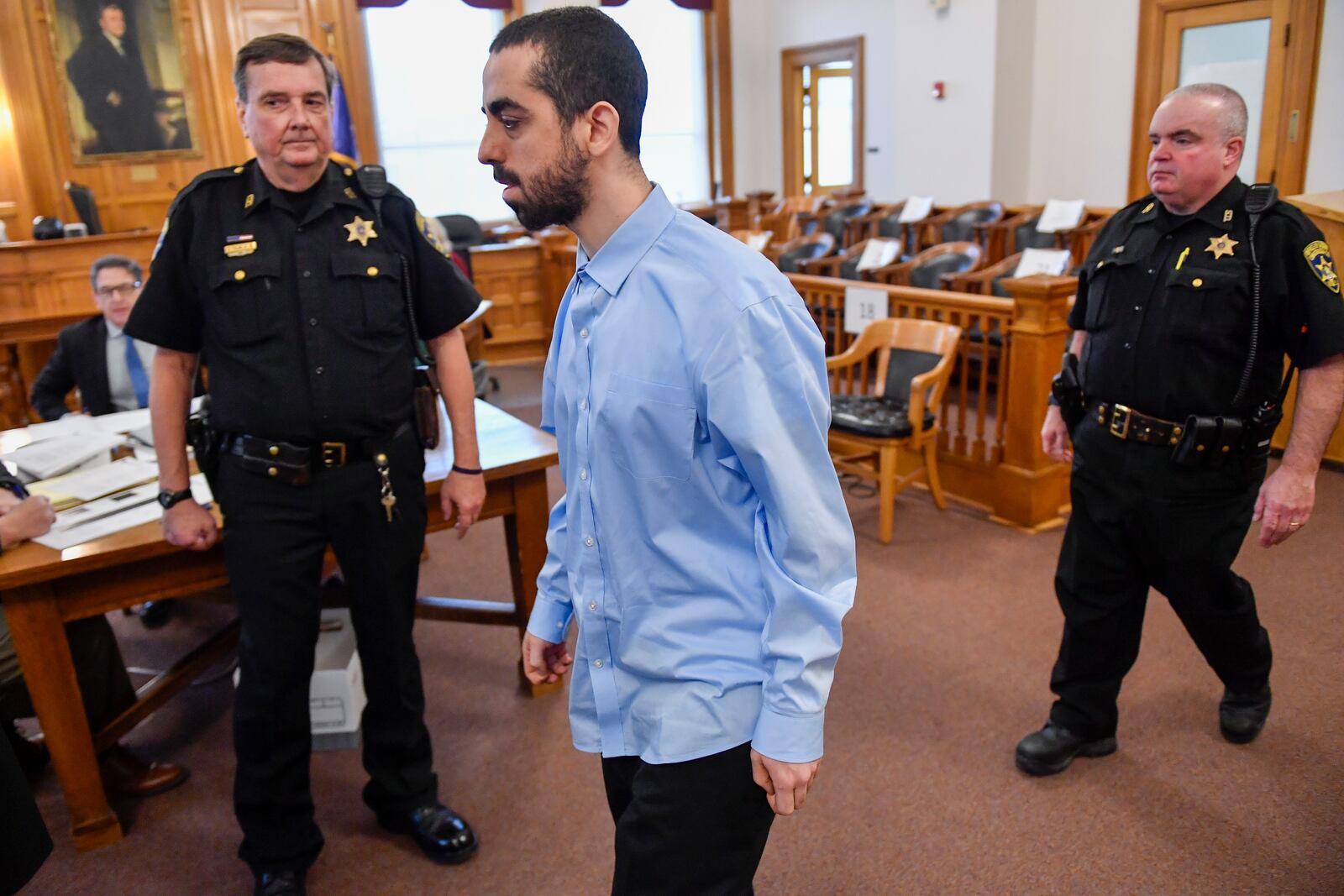 Hadi Matar, center, charged with severely injuring author Salman Rushdie in a 2022 knife attack, is led into Chautauqua County court before the start of jury selection in Mayville, N.Y., Tuesday, Feb. 4, 2025. (AP Photo/Adrian Kraus)