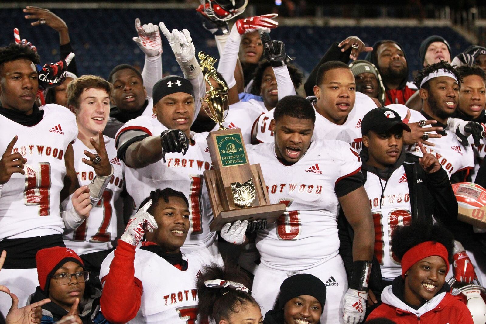 Trotwood-Madison twin brothers Keon’tae (left) and Ke’Shawn Huguely (both holding trophy) celebrate with teammates. Trotwood defeated Mansfield Senior 14-7 in overtime to win the Division III high school football championship at Tom Benson Hall of Fame Stadium in Canton on Friday. It was the Rams’ (12-3) third football state title, along with its 2011 and ‘17 championship teams. Anna also won a D-VI title on Friday and Marion Local will bid for the D-VII state title on Saturday. MARC PENDLETON / STAFF