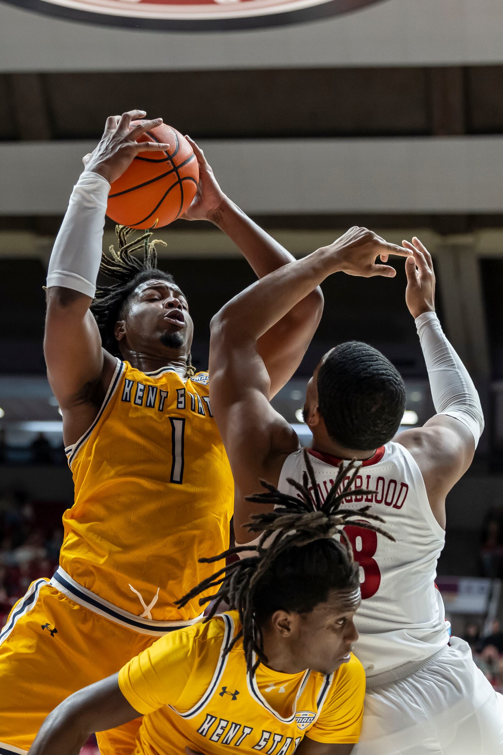 Kent State forward VonCameron Davis (1) rebounds the ball over Alabama guard Chris Youngblood (8) during the first half of an NCAA college basketball game, Sunday, Dec. 22, 2024, in Tuscaloosa, Ala. Kent State guard Jamal Sumlin (4) is seen at bottom of frame. (AP Photo/Vasha Hunt)