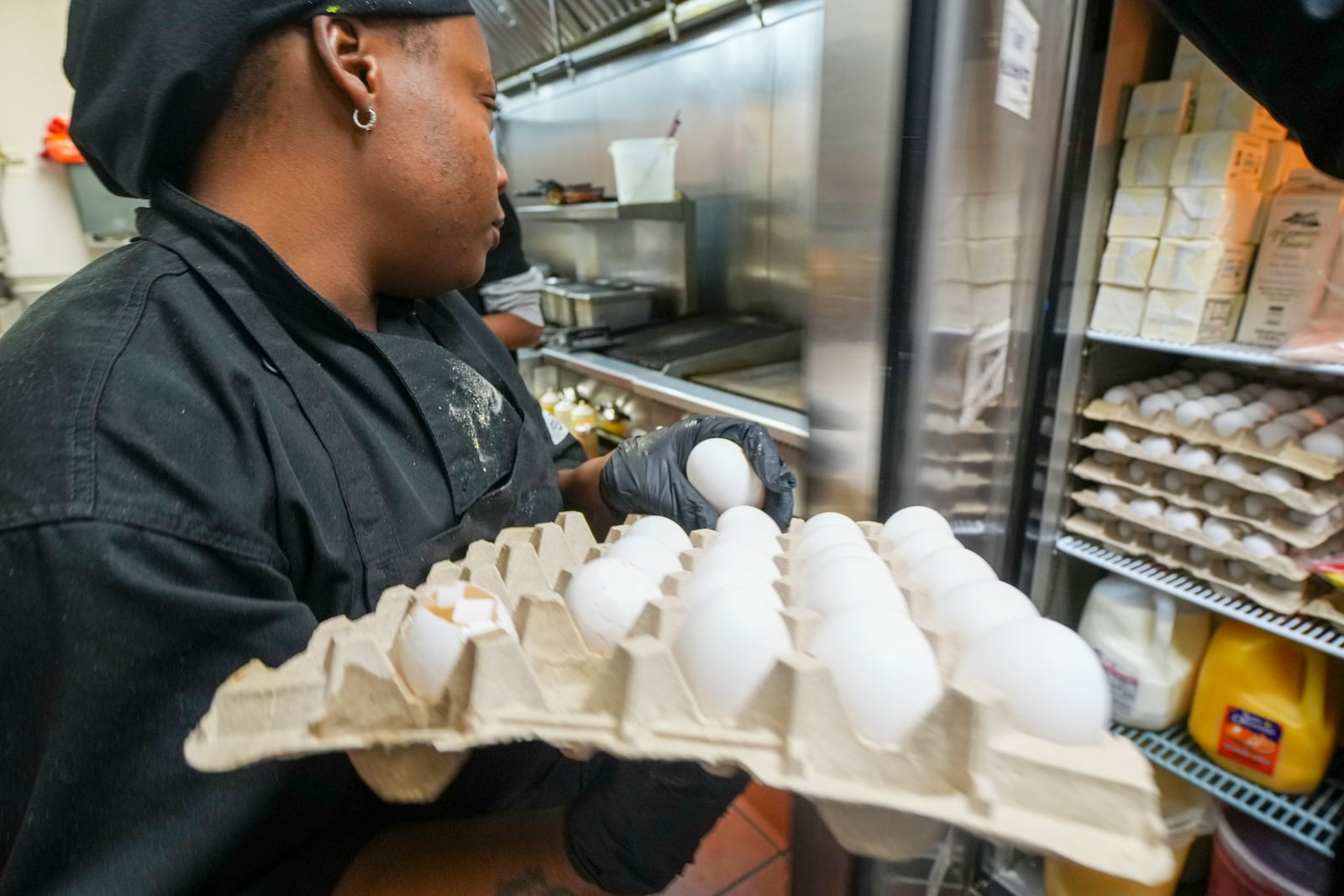 Johkiya Pierre holds a carton of eggs while preparing a fresh omelette at The Breakfast Brothers restaurant, Wednesday, Feb. 12, 2025, in Arlington, Texas. (AP Photo/Julio Cortez)