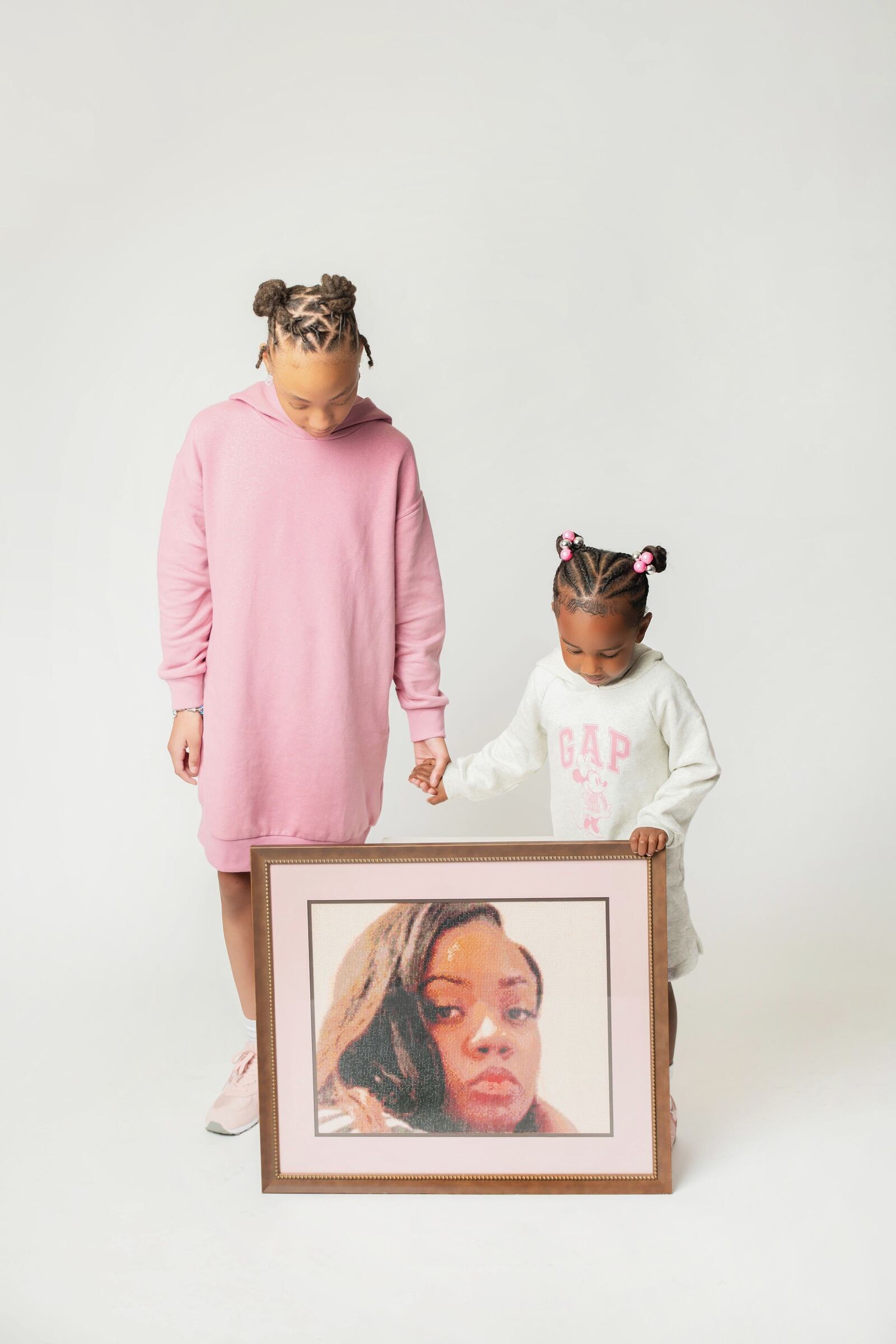 At Christmas last December, Lois Oglesby’s two daughters, Hannah (left) who is now 12, and Reign, who is now 5, posed with a photo of their late mother. (Contributed Photo)