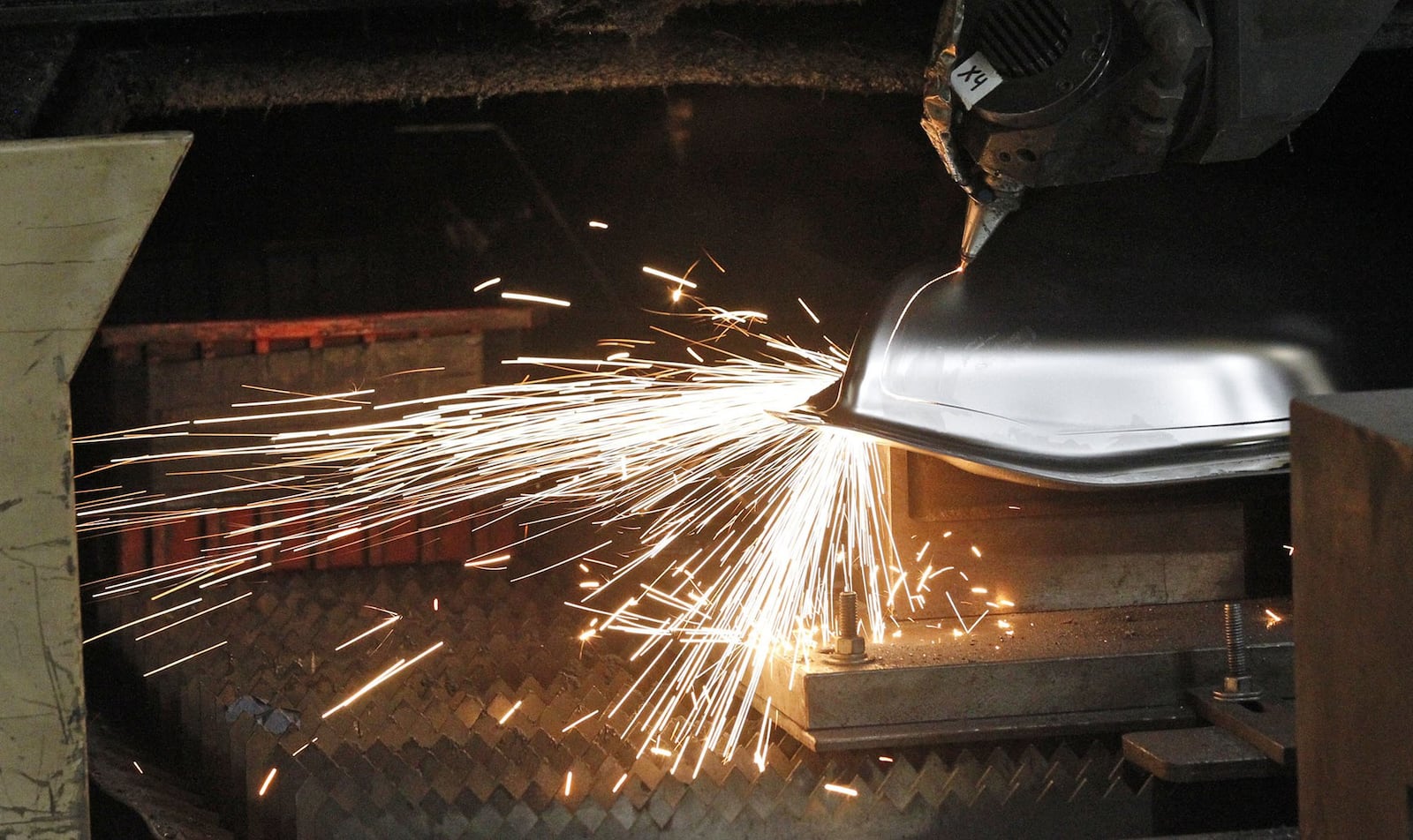 A CNC laser cutting machine cuts a part at Staub Manufacturing Solutions of Dayton in this file photo from 2018. TY GREENLEES / STAFF