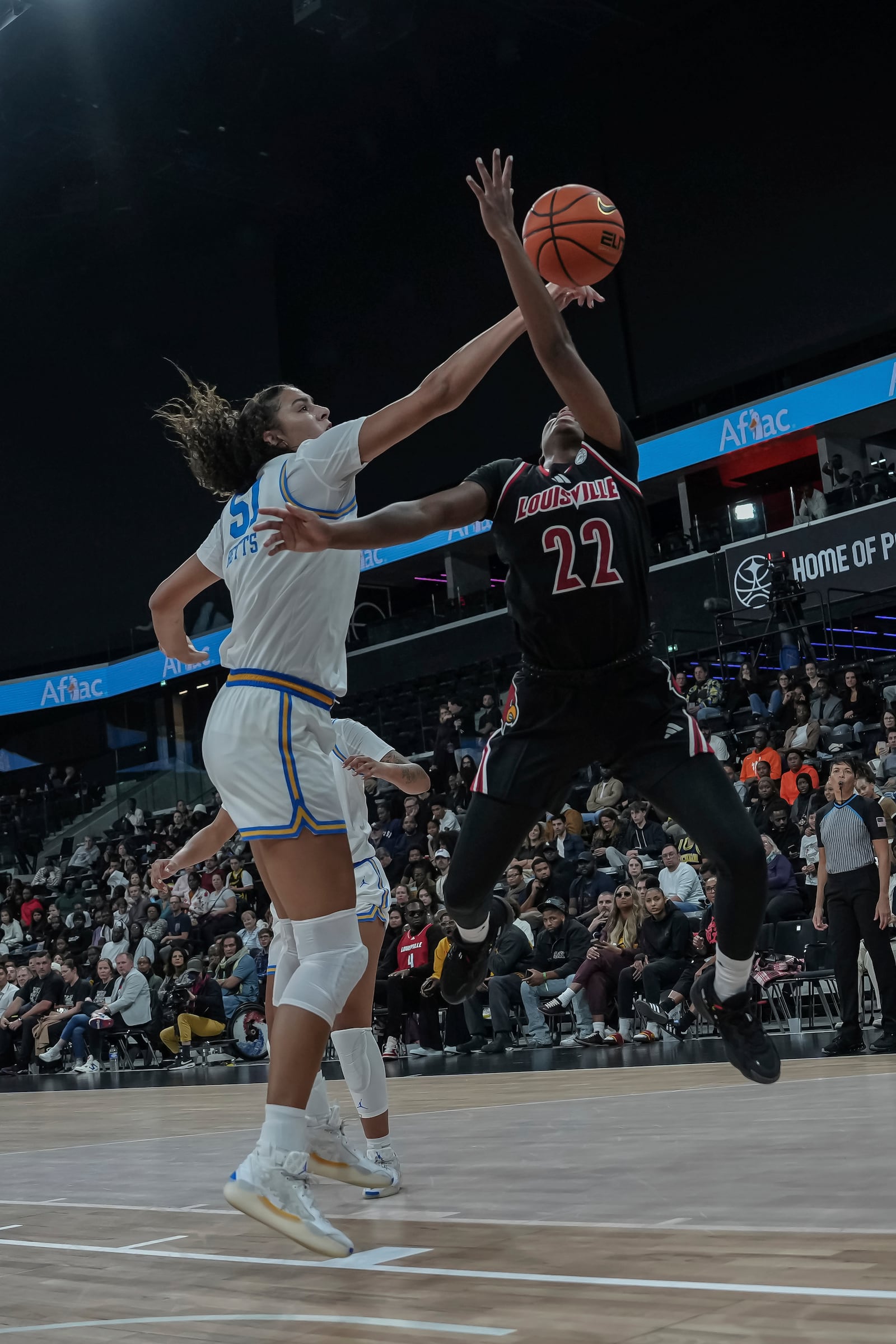 UCLA center Lauren Betts knocks the ball away from Louisville's guard Tajianna Roberts (22) during an NCAA college basketball game Monday, Nov. 4, 2024, in Paris, France. (AP Photo/Aurelien Morissard)