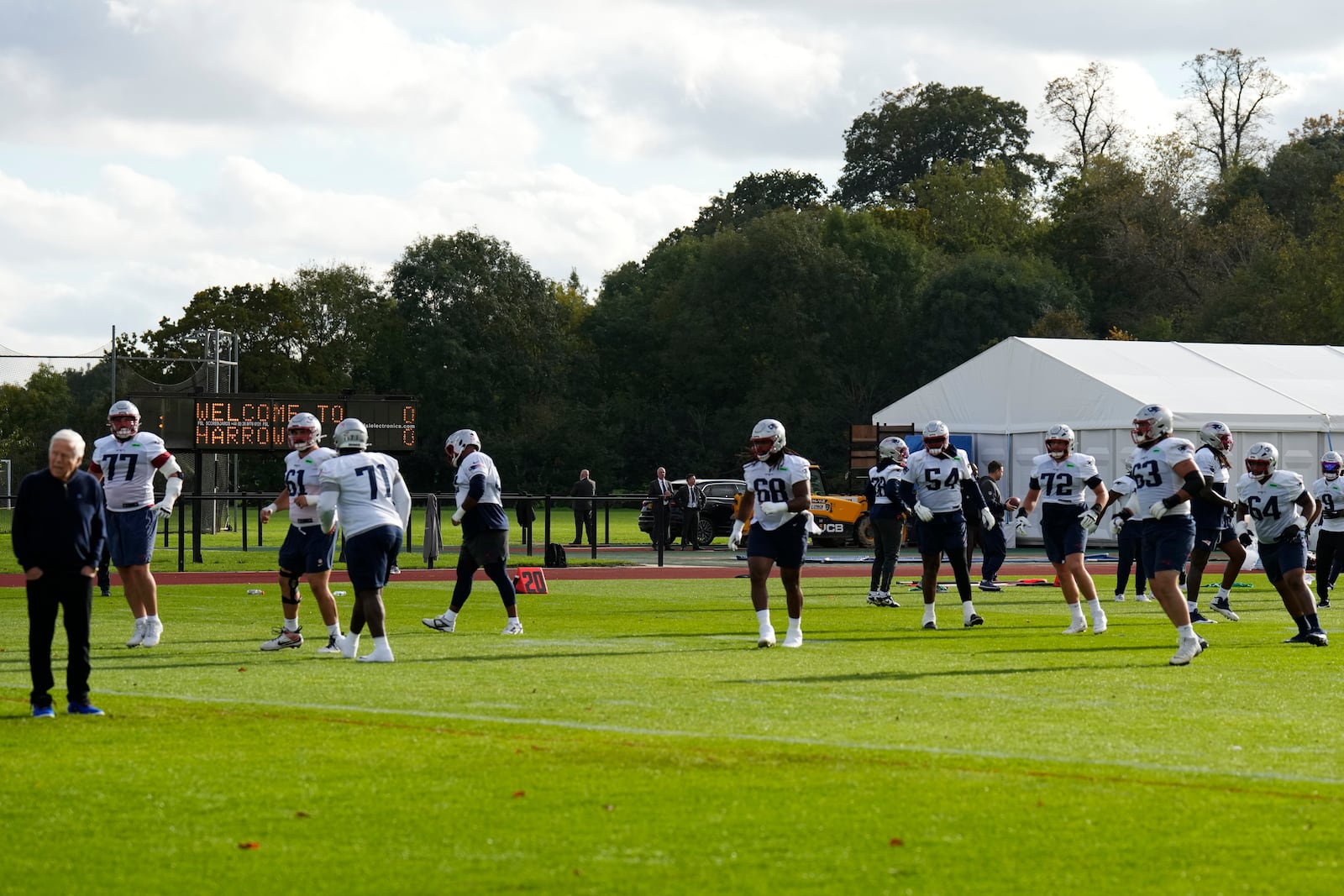 New England Patriots players warm up during NFL football practice, Friday, Oct. 18, 2024, in Harrow, England. (AP Photo/Steve Luciano)