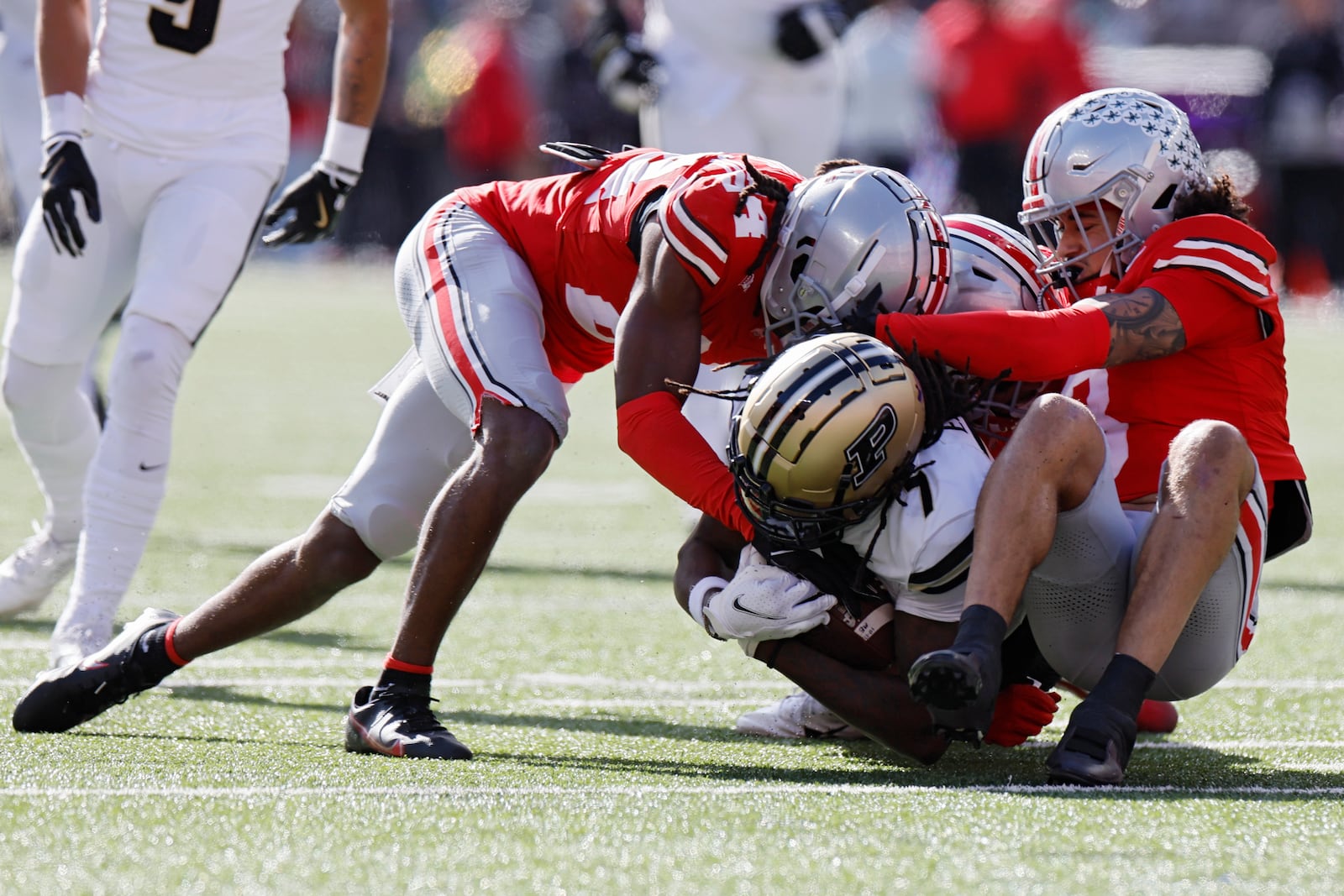 Ohio State defensive lineman Jason Moore, left, and defensive back Lathan Ransom, right, tackle Purdue receiver Jahmal Edrine during the first half of an NCAA college football game Saturday, Nov. 9, 2024, in Columbus, Ohio. (AP Photo/Jay LaPrete)