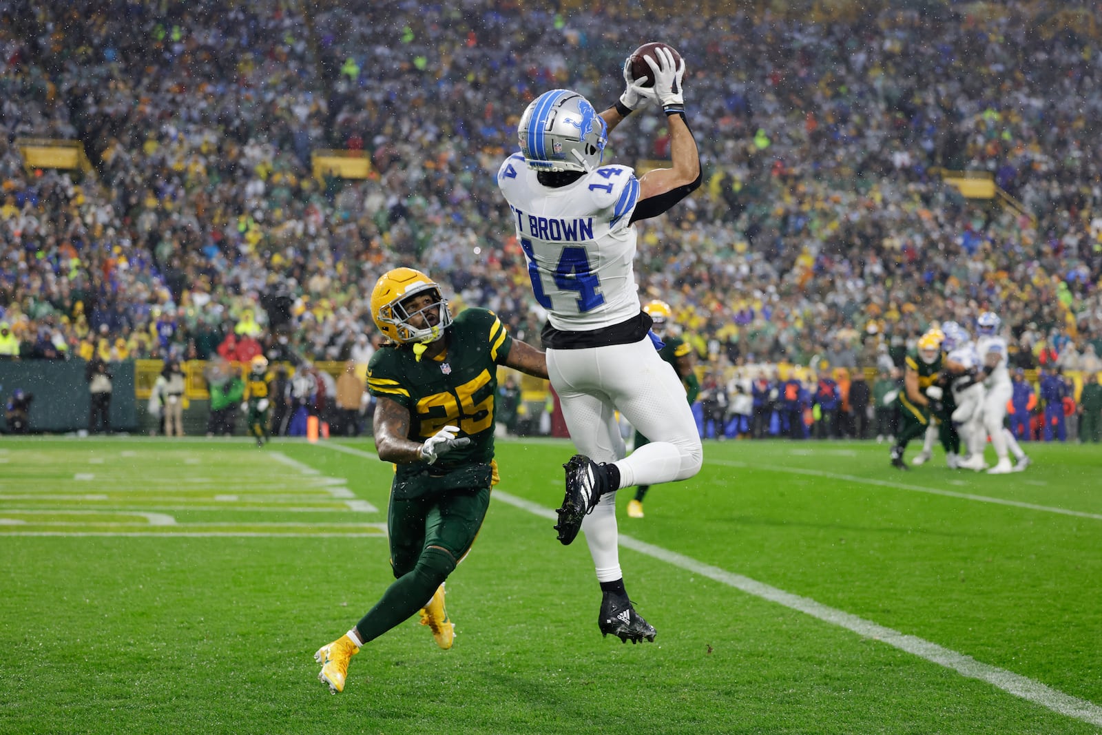 Detroit Lions wide receiver Amon-Ra St. Brown (14) catches a touchdown past Green Bay Packers cornerback Keisean Nixon (25) during the first half of an NFL football game Sunday, Nov. 3, 2024, in Green Bay, Wis. (AP Photo/Matt Ludtke)