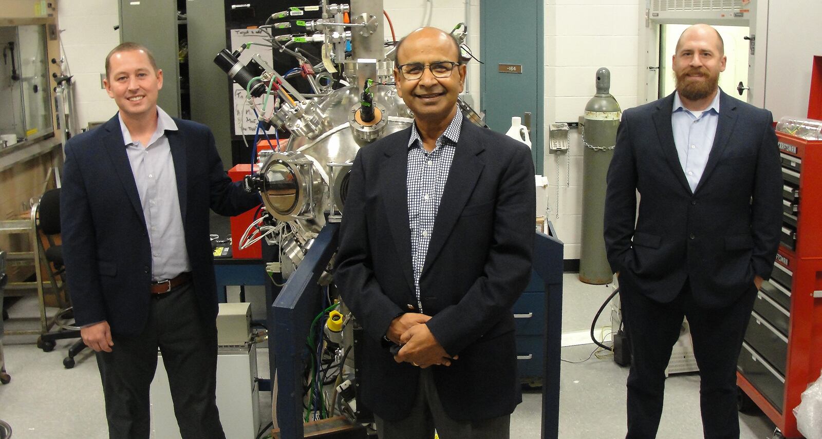 From left: Dr. Nick Glavin, Dr. Ajit Roy and Dr. Michael McConney stand with a nanomaterial deposition chamber at the Air Force Research Laboratory’s Materials and Manufacturing Directorate at Wright Patterson Air Force Base on Sept. 24, 2021. The trio are increasing the availability of nano materials by building stronger ties with industry, government and academia in India. (U.S. Air Force photo/Patrick Foose).