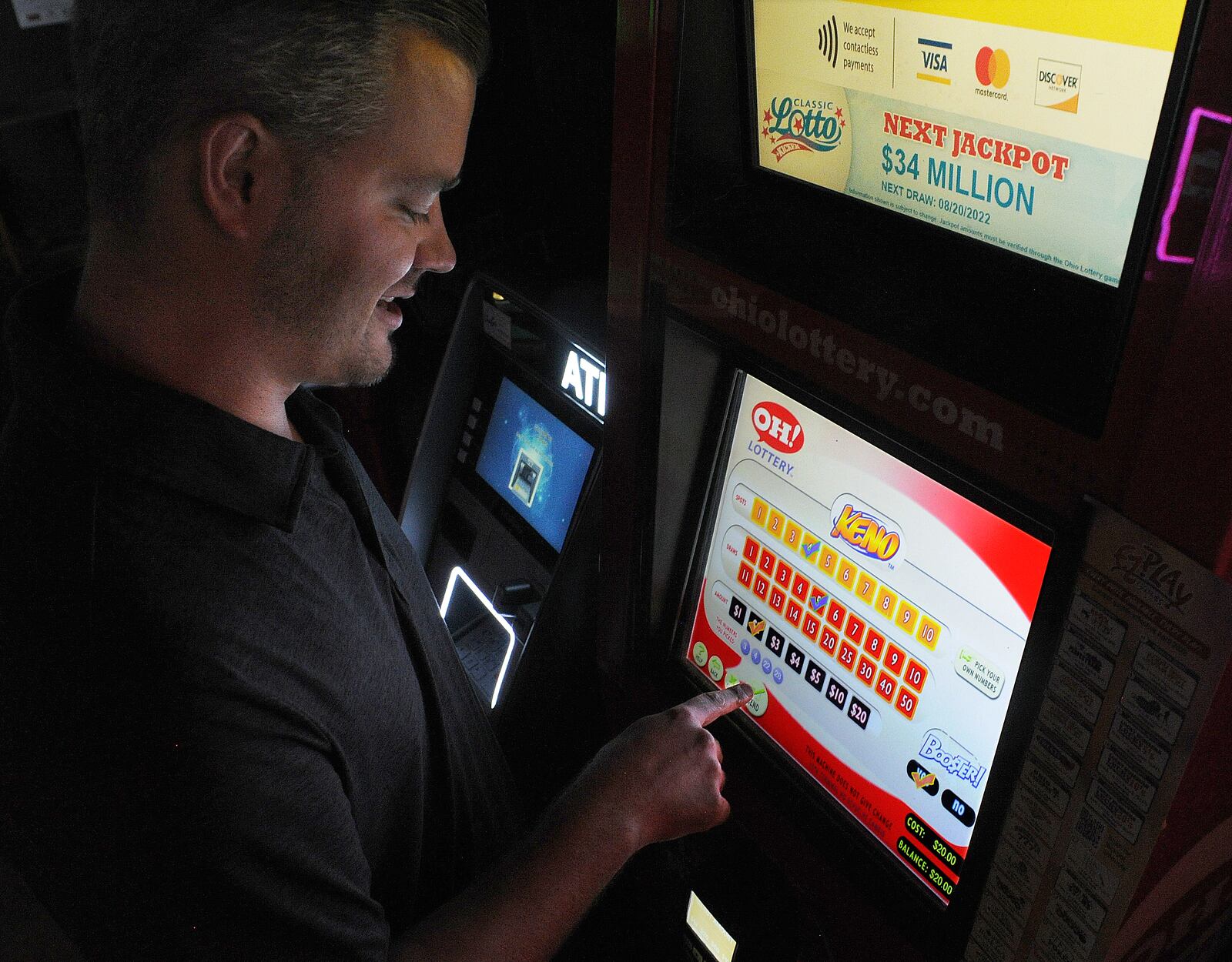 Matthew L. Adair plays a KENO game on Thursday Aug. 18, 2022 at Romer's Bar & Grill in Bellbrook. Starting in January, Ohioans will be able to place sports bets at kiosks similar to this one, at state-approved locations. Romer's is among 86 pre-approved sites in the Dayton area. MARSHALL GORBY\STAFF