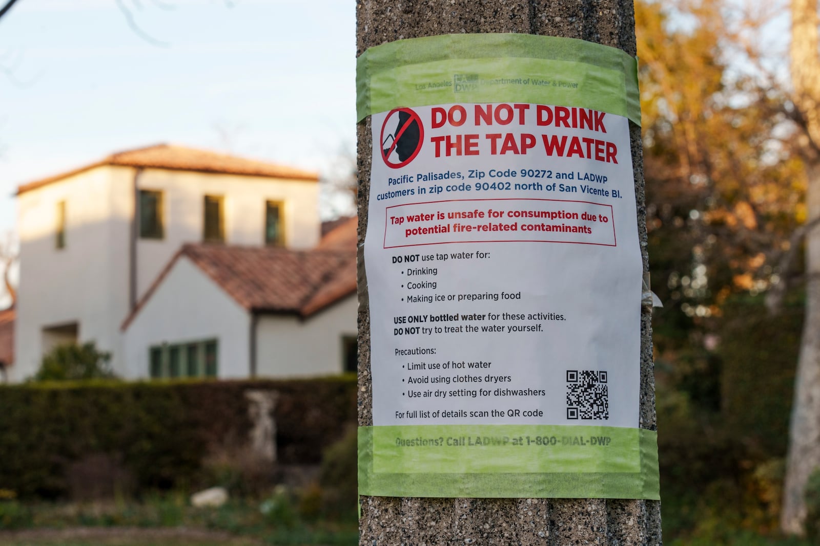 A sign posted by the Los Angeles Department of Water and Power reads: " Do Not Drink The Tap Water, " as President Donald Trump tours the Palisades Fire zone damage in the Pacific Palisades neighborhood of Los Angeles Friday, Jan. 24, 2025. (AP Photo/Damian Dovarganes)