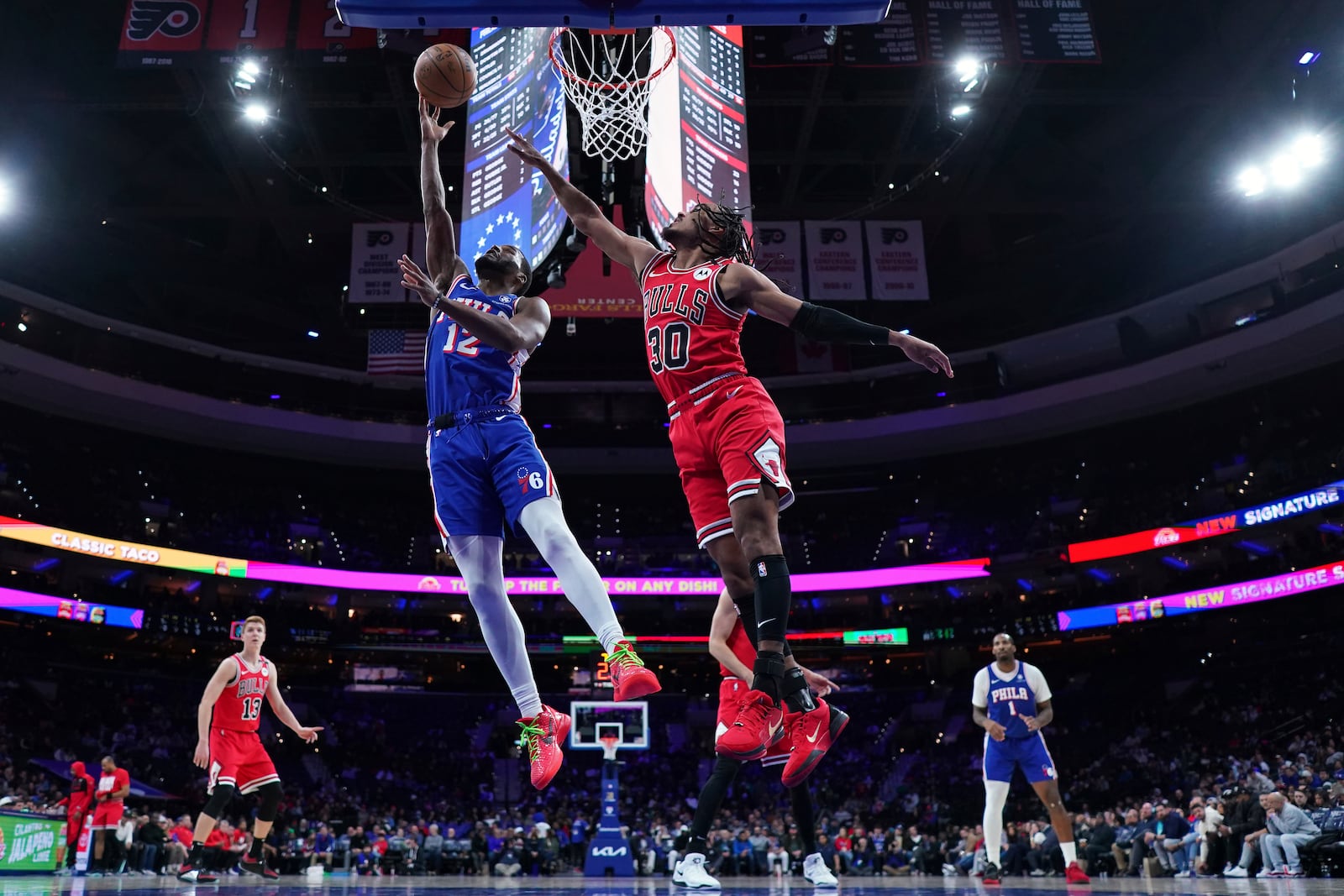 Philadelphia 76ers' Jared Butler, left, goes up for a shot against Chicago Bulls' Tre Jones during the second half of an NBA basketball game Monday, Feb. 24, 2025, in Philadelphia. (AP Photo/Matt Slocum)