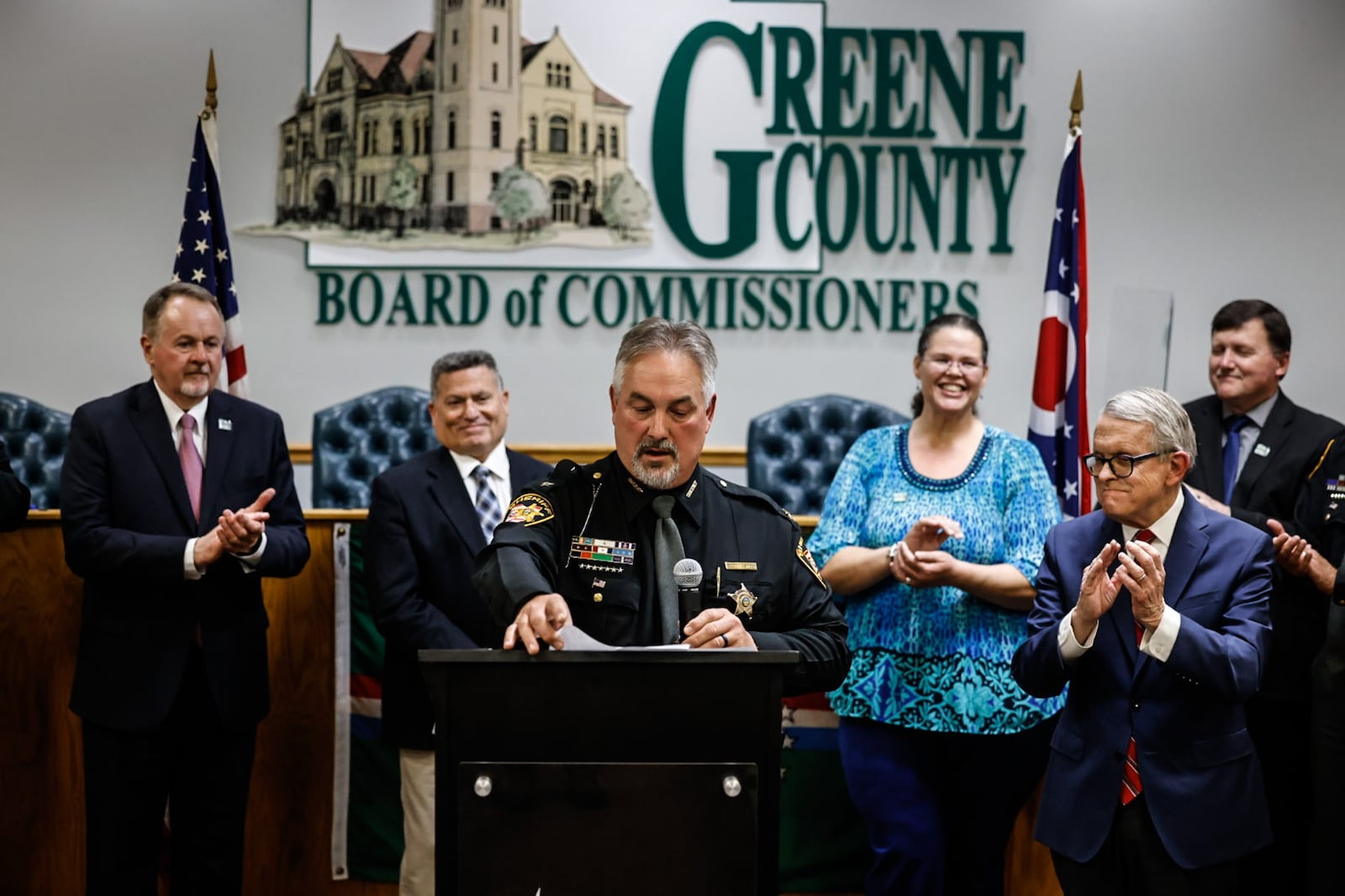 Greene County Sheriff Scott Anger talks about former sheriff Gene Fischer at the Greene County Board of Commissioners Friday, April 21, 2023. Ohio Gov. Mike DeWine, right, toured the Greene County Jail and announced a $15 million grant to support construction of a new jail. JIM NOELKER/STAFF