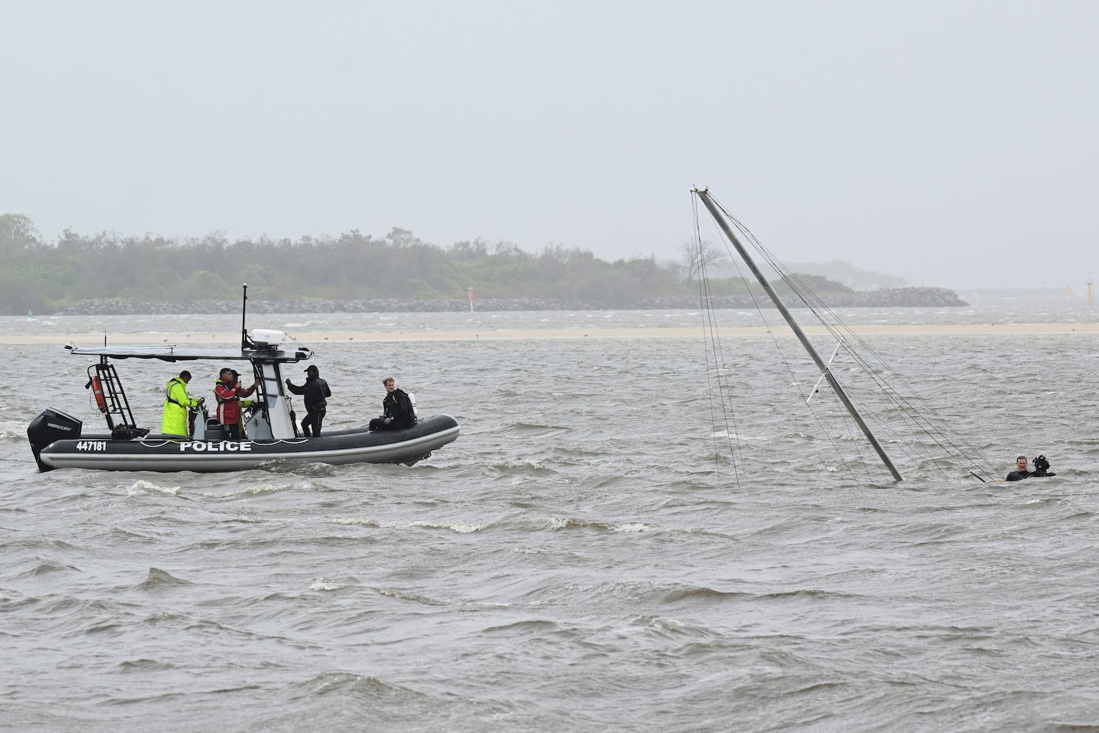 Police divers attend a sunken yacht in the Broadwater at Labrador following Cyclone Alfred on the Gold Coast, Australia, Saturday, March 8, 2025. (Dave Hunt/AAP Image via AP)