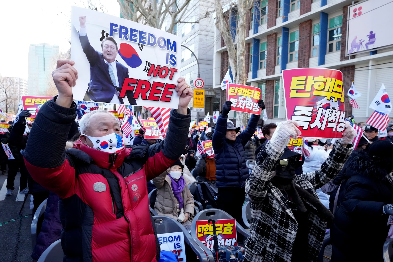 Supporters of impeached South Korean President Yoon Suk Yeol hold signs during a rally to oppose his impeachment near the Constitutional Court in Seoul, South Korea, Thursday, Feb. 13, 2025. The letters read "Nullity Impeachment." (AP Photo/Lee Jin-man)