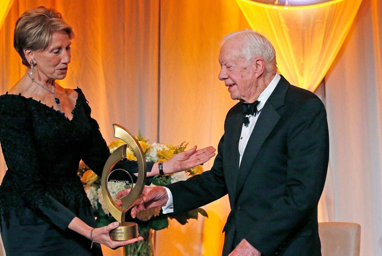 FILE - Former President Jimmy Carter accepts the O'Connor Justice Prize from former U.S. Ambassador to Finland Barbara Barrett at The Sandra Day O'Connor College of Law at Arizona State University in Phoenix, Jan. 27, 2017. The prize recognizes people who have made extraordinary contributions to advancing the rule of law, justice and human rights. (AP Photo/Ross D. Franklin, File)