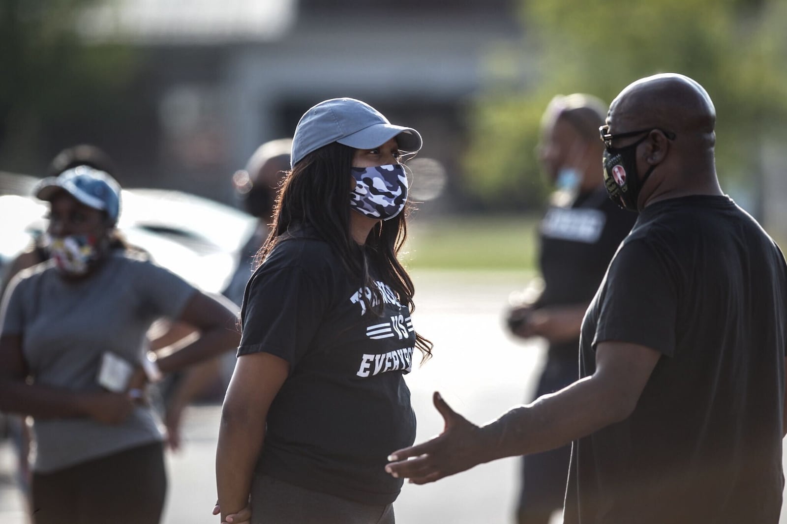 Trotwood-Madison High School parents Dominique Vinzant, left, and Eric Davis who both have sons on the football team join other parents Monday, Aug. 31, 2020, in the school parking lot to discuss the school’s decision to opt out of fall sports due to the coronavirus pandemic.